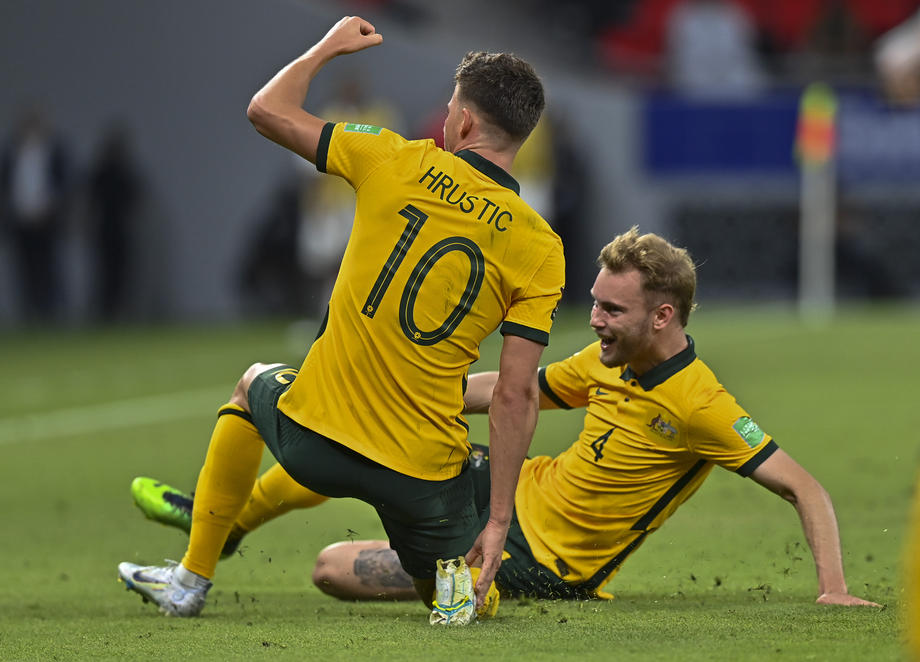 epa10000985 Ajdin Hrustic (L) of Australia celebrates with teammate Nathaniel Atkinson (R) after scoring the 2-1 lead during the FIFA World Cup 2022 Asian Qualifiers playoff soccer match between the United Arab Emirates and Australia in Al Rayyan, Qatar, 07 June 2022.  EPA-EFE/NOUSHAD THEKKAYIL