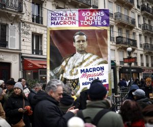 epa10415667 A protester holds a poster depicting French president Emmanuel Macron during a national strike against the government's reform of the pension system, in Paris, France, 19 January 2023. The French government plans to delay the minimum retirement age from 62 to 64 by 2030.  EPA/YOAN VALAT
