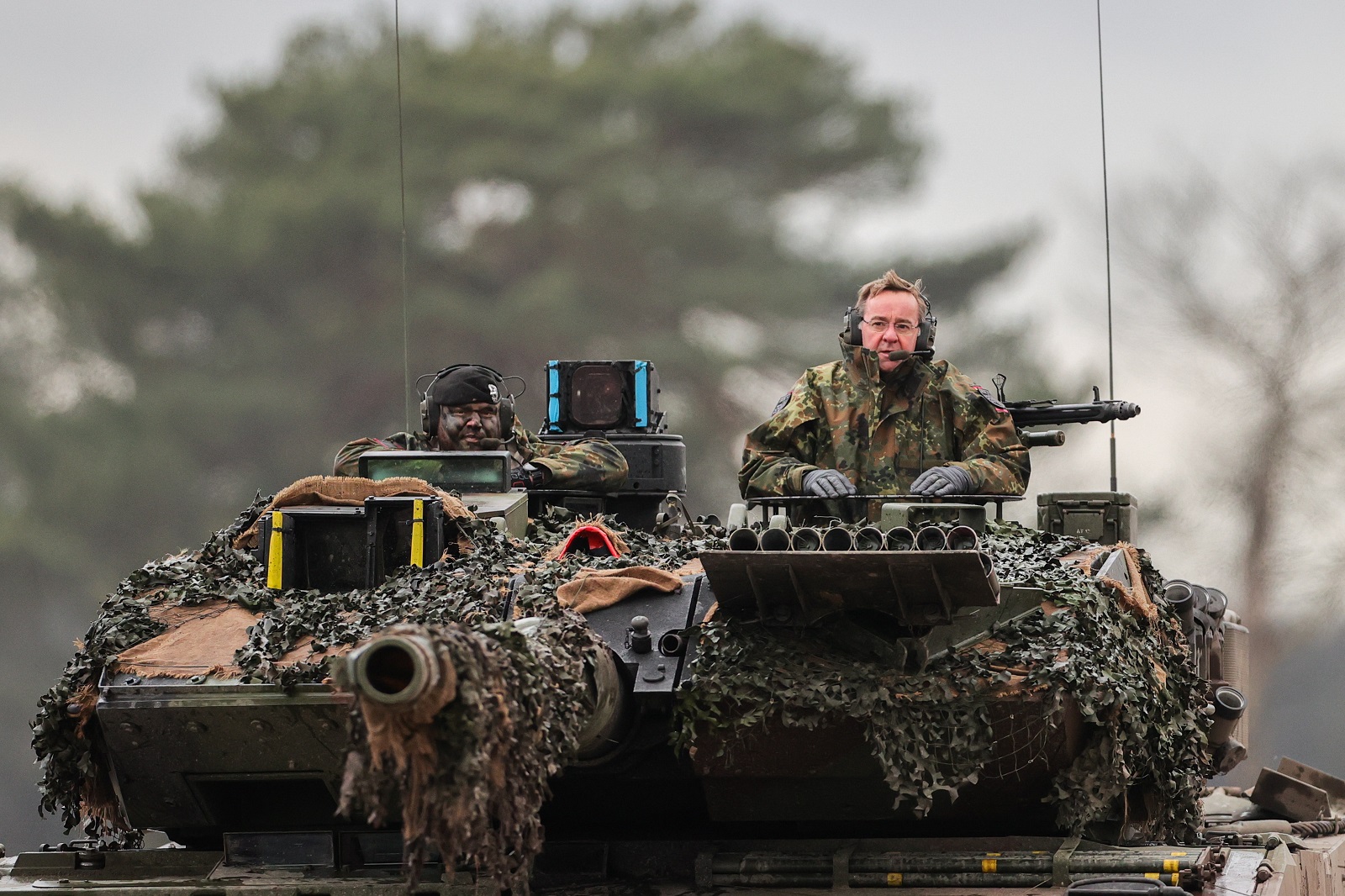 epa10442779 German Defense Minister Boris Pistorius (R) rides on the turret of a 'Leopard 2 A6' battle tank during his visit to German armed forces Bundeswehr soldiers of the tank battalion 203 in Augustdorf, Germany, 01 February 2023. According to the German government's decision to supply 14 Leopard 2 tanks to Ukraine, Pistorius got informed about the performance of the weapon system.  EPA/FRIEDEMANN VOGEL