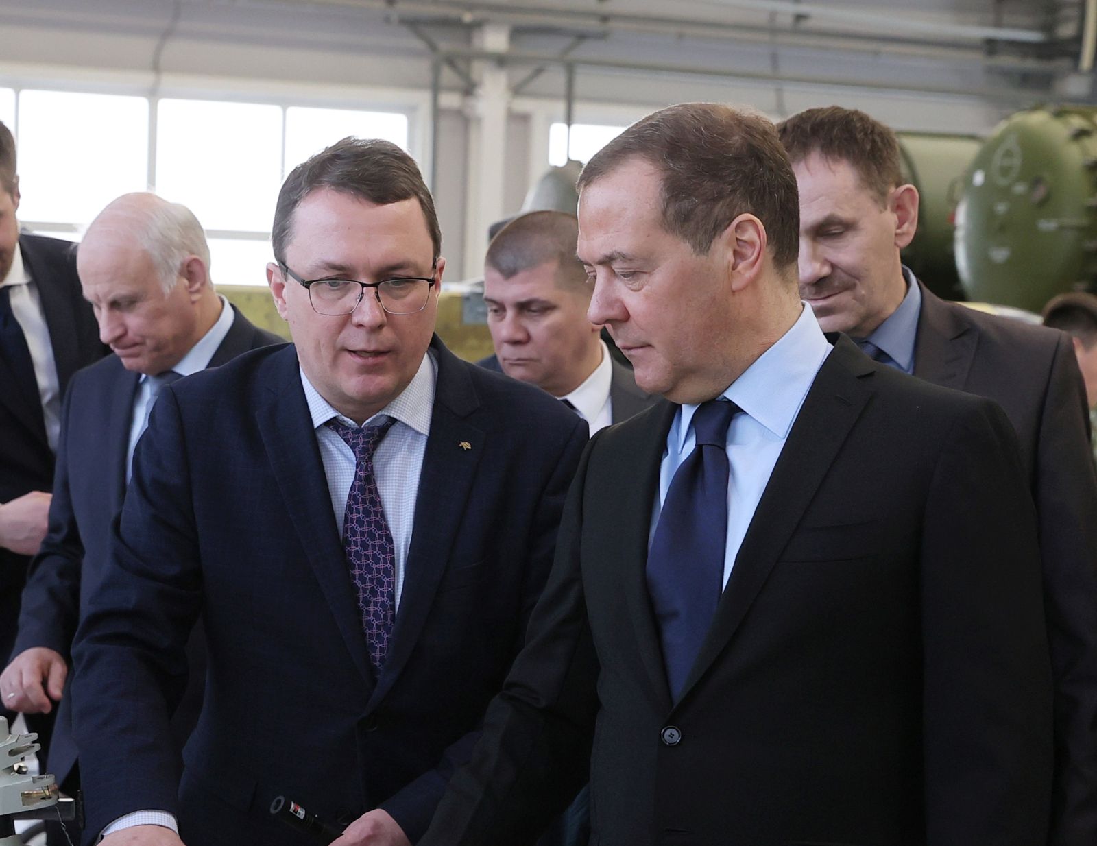epa10444475 Deputy head of Russia's Security Council and chairman of the United Russia party Dmitry Medvedev (R) listens to General Director of Raduga Sergei Bogatikov (C) as he visits the Raduga State Machine Building Construction Bureau named after A. Bereznyak, in Dubna, Moscow region, Russia, 02 February 2023.  EPA/EKATERINA SHTUKINA / SPUTNIK POOL MANDATORY CREDIT