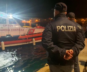 epa10445200 Police officers on the quay of the port wait for the boat containing the bodies of 8 migrants in Lampedusa, Sicily, Italy, 03 February 2023. The soldiers of a Coast Guard patrol boat rescued the boat, with dozens of North Africans on board and also the bodies.  EPA/Concetta Rizzo