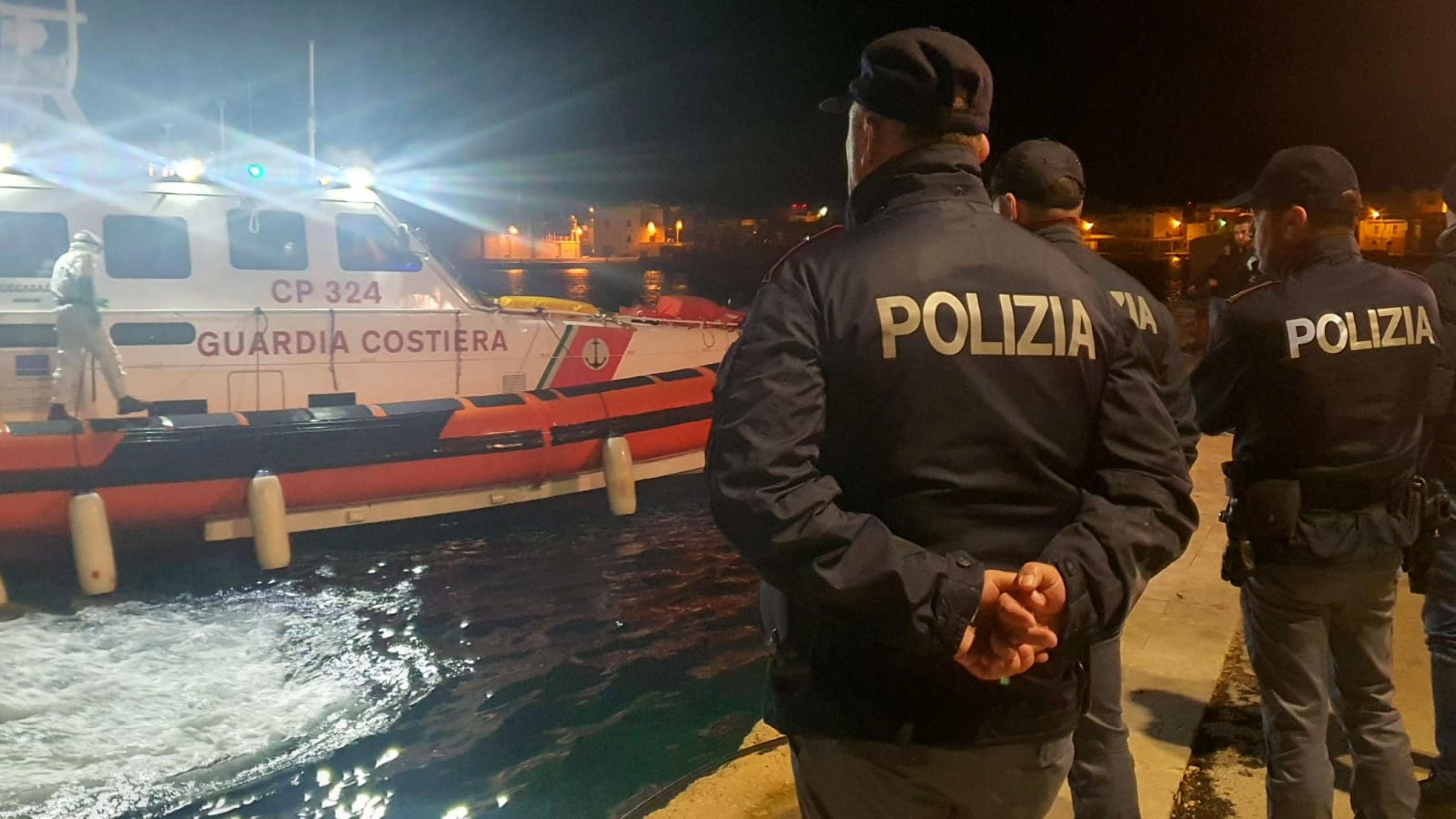 epa10445200 Police officers on the quay of the port wait for the boat containing the bodies of 8 migrants in Lampedusa, Sicily, Italy, 03 February 2023. The soldiers of a Coast Guard patrol boat rescued the boat, with dozens of North Africans on board and also the bodies.  EPA/Concetta Rizzo