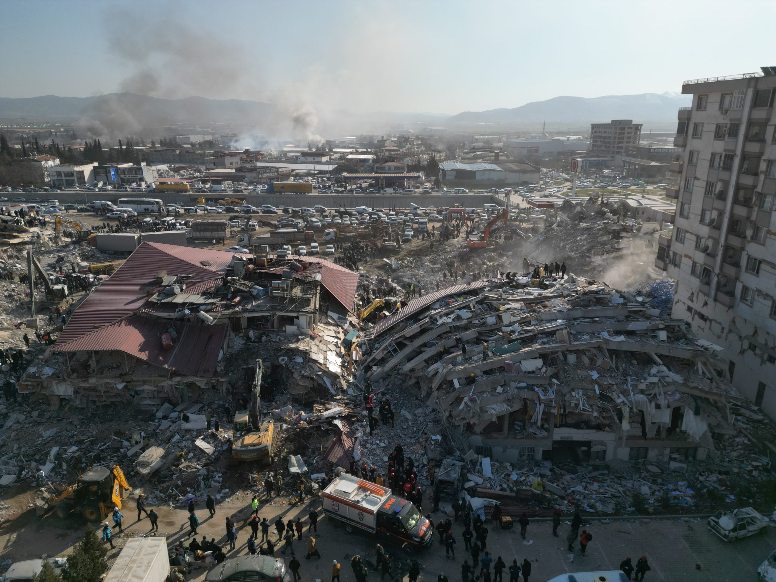 epa10457386 A photo taken with a drone shows emergency services working among the rubble of collapsed buildings in the aftermath of a poweful earthquake in Kahramanmaras, southeastern Turkey, 09 February 2023. More than 17,000 people have died and thousands more were injured after two major earthquakes struck southern Turkey and northern Syria on 06 February. Authorities fear the death toll will keep climbing as rescuers look for survivors across the region.  EPA/ABIR SULTAN