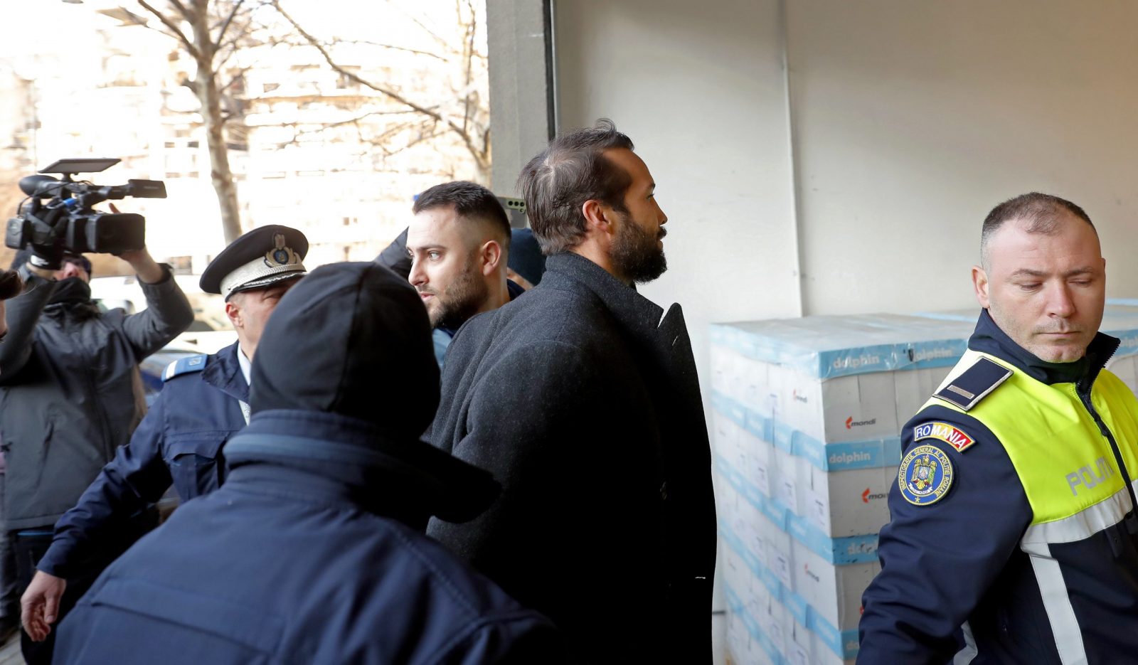 epa10464608 Tristan Tate (C), the brother of former professional kickboxer and social media influencer Andrew Tate (not pictured) is escorted by police officers to the Directorate for Investigating Organized Crime and Terrorism (DIICOT) headquarters to be questioned in Bucharest, Romania, 13 February 2023. On 29 December 2022, Andrew Tate and his brother Tristan were arrested as a result of the DIICOT inquiry under the charges of human trafficking and intention to form an organized crime group. Romanian police stated that the two brothers and their associates coerced victims for creating a paid pornography service for social media platforms.  EPA/ROBERT GHEMENT