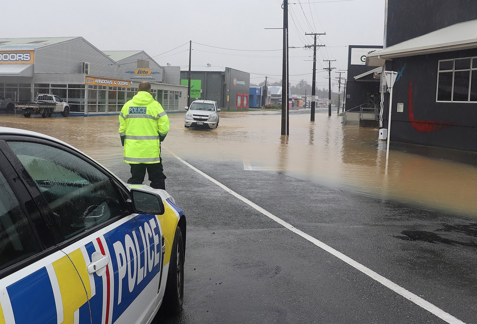 epa10465753 A handout photo made available by the New Zealand Police assisting motorists around flood waters in Whangārei, New Zealand, issued 13 February 2023. The New Zealand government is considering a national state of emergency, with tens of thousands of homes without power and Cyclone Gabrielle's worst still to come as the storm surges south.  EPA/NEW ZEALAND POLICE HANDOUT AUSTRALIA AND NEW ZEALAND OUT HANDOUT EDITORIAL USE ONLY/NO SALES/NO ARCHIVES