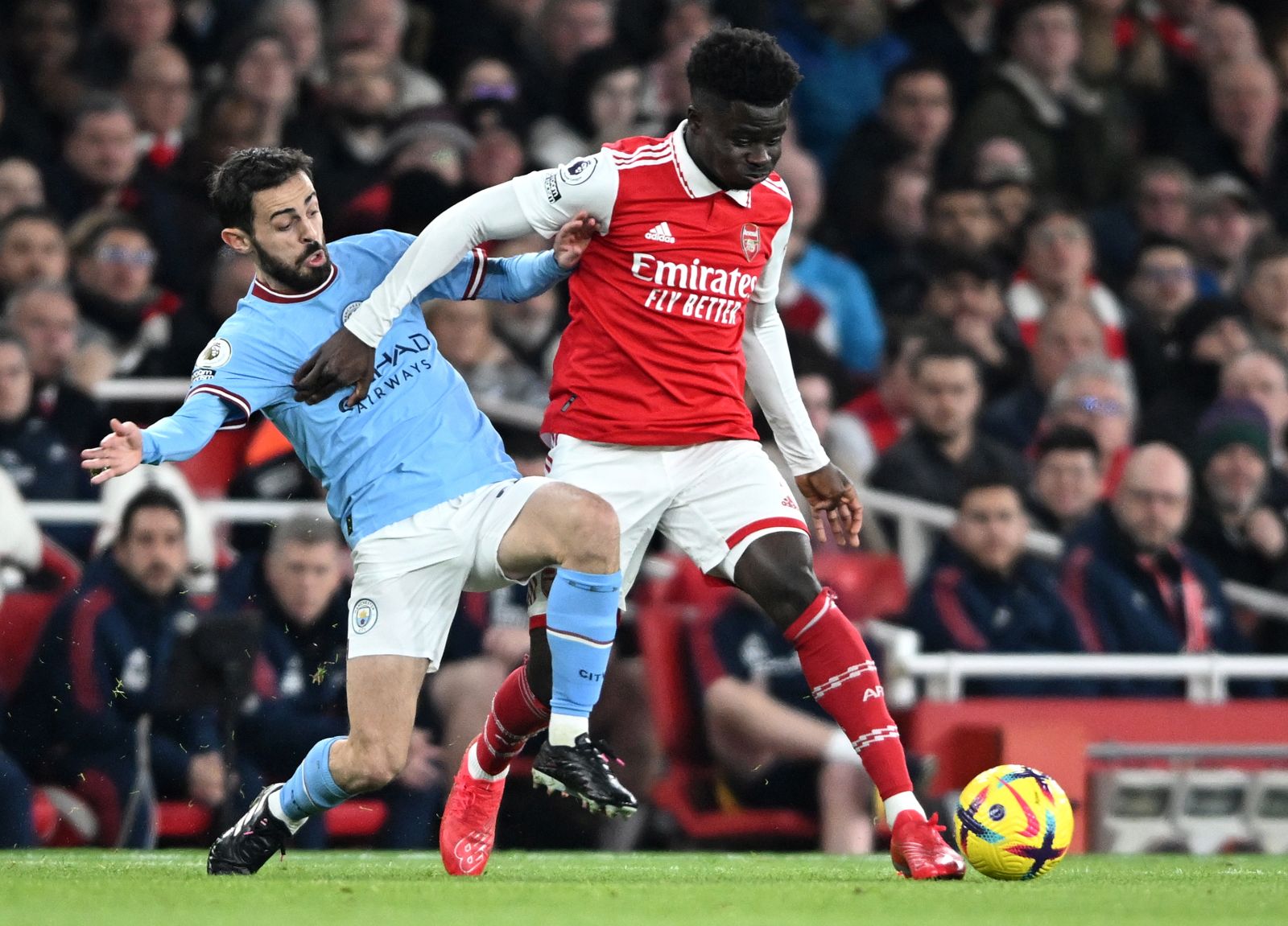 epa10468986 Bukayo Saka (R) of Arsenal in action against Bernardo Silva of Manchester City during the English Premier League soccer match between Arsenal London and Manchester City in London, Britain, 15 February 2023.  EPA/Daniel Hambury EDITORIAL USE ONLY. No use with unauthorized audio, video, data, fixture lists, club/league logos or 'live' services. Online in-match use limited to 120 images, no video emulation. No use in betting, games or single club/league/player publications