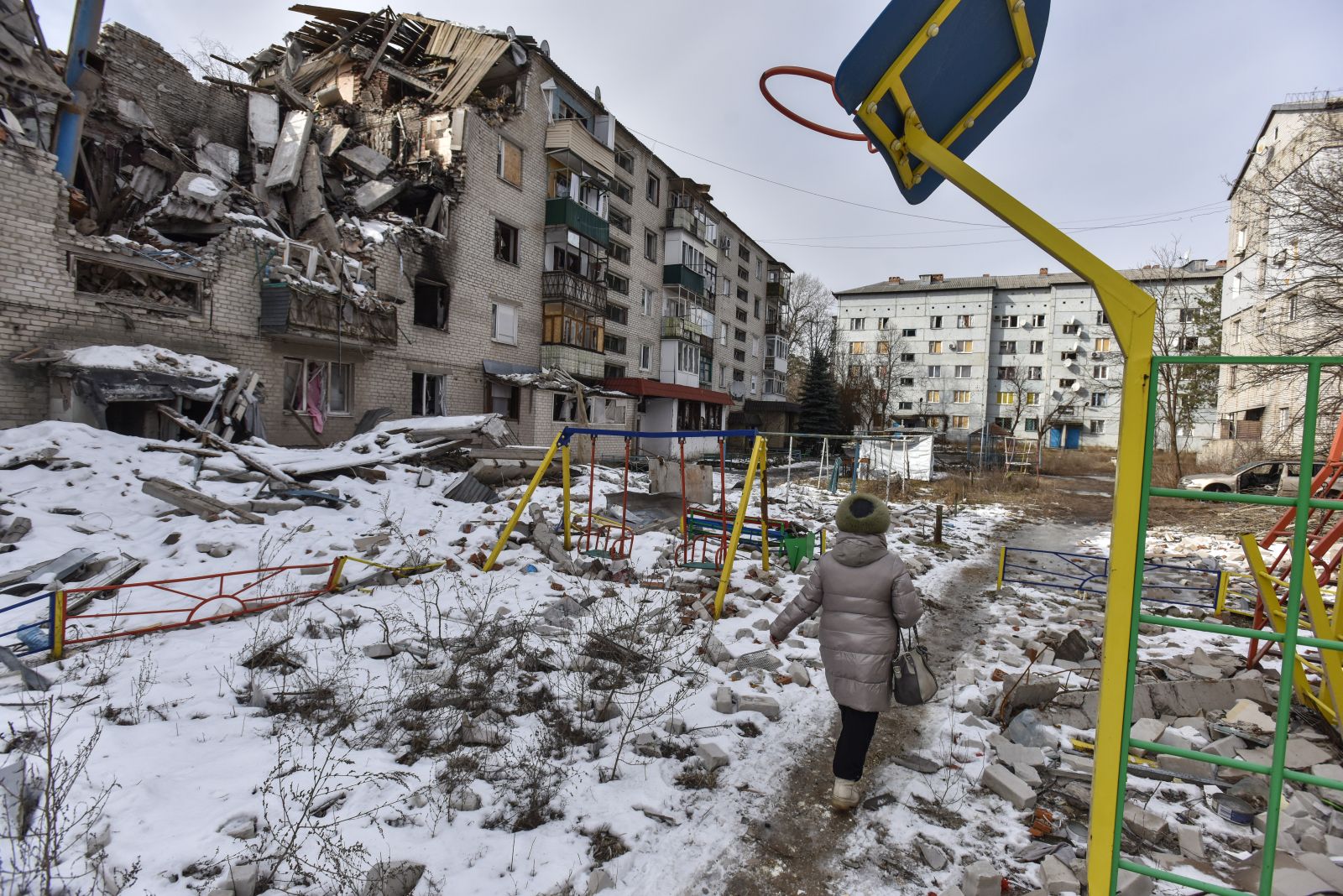 epa10488305 A woman walks past a damaged building in Sviatohirsk, Donetsk region, eastern Ukraine, 24 February 2023. Russian troops entered Ukrainian territory on 24 February 2022, starting a conflict that has provoked destruction and a humanitarian crisis. One year on, fighting continues in many parts of the country.  EPA/OLEG PETRASYUK