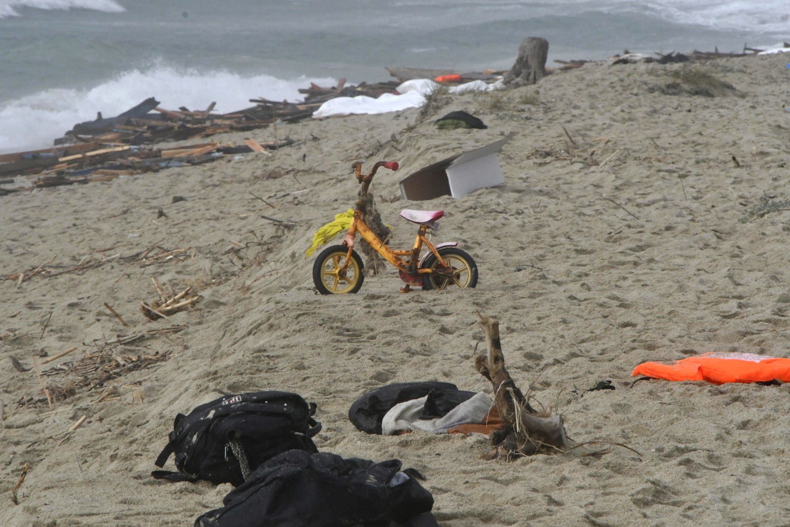 epa10491828 Debris, among them a bicycle for children, washed ashore at a beach near Cutro, Crotone province, southern Italy, 26 February 2023. Italian authorities said on 26 February that at least 30 bodies were found on the beach and in the sea near Crotone, in the southern Italian region of Calabria, after a boat carrying migrants sank in rough seas near the coast. About forty people survived the accident, Italian firefighters added. Authorities fear the death toll will climb as rescuers look for survivors.  EPA/GIUSEPPE PIPITA