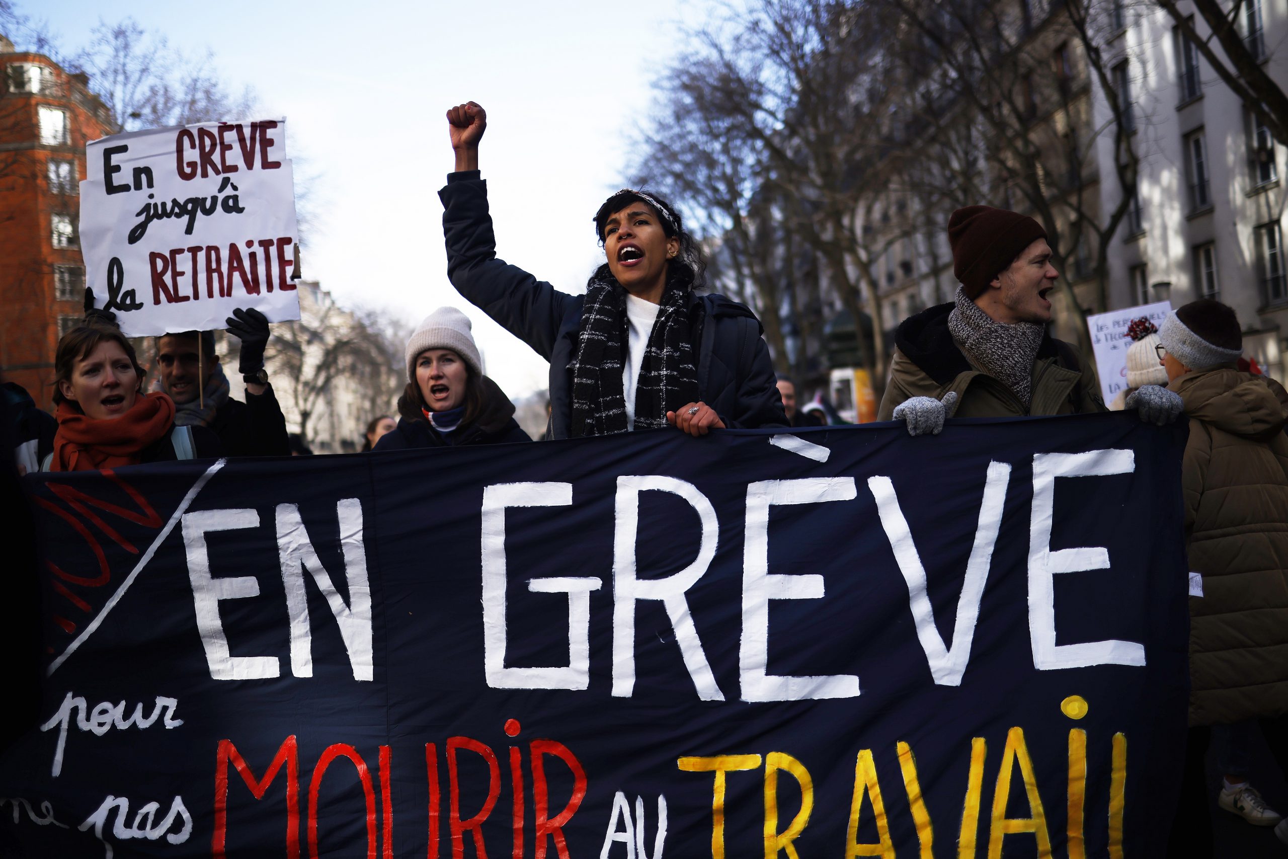 epa10441335 Demonstrators hold a banner reading 'On strike so as not to die at work' as thousands of protesters take part in a demonstration against the government's reform of the pension system, in Paris, France, 31 January 2023. The French government plans to raise the minimum retirement age from 62 to 64 by 2030.  EPA/YOAN VALAT