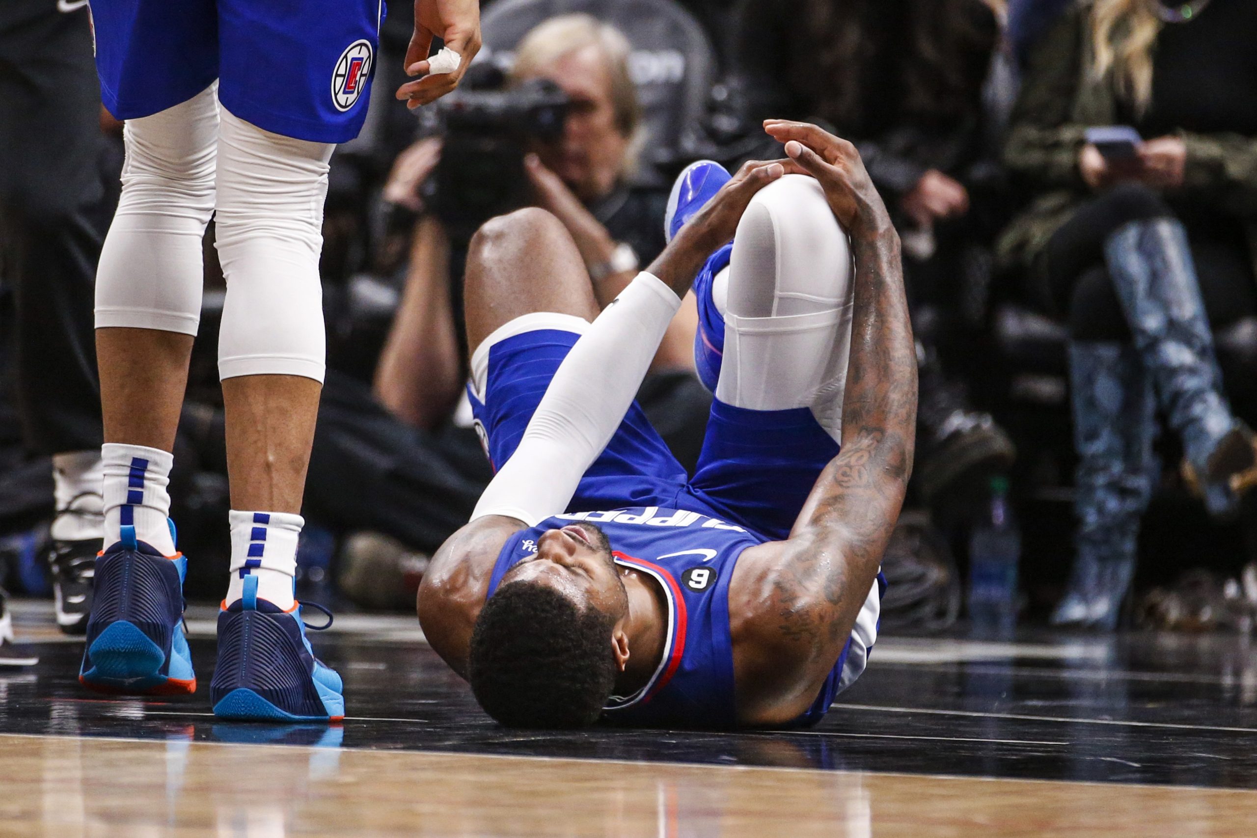 Los Angeles Clippers forward Paul George, right, lies on the court after an injury during the second half of an the team's NBA basketball game against the Oklahoma City Thunder on Tuesday, March 21, 2023, in Los Angeles. (AP Photo/Ringo H.W. Chiu)