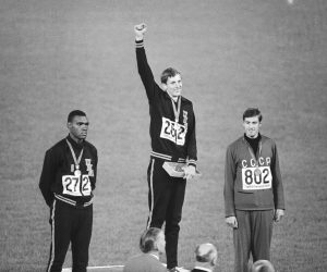 Dick Fosbury of the United States, originator of the "Fosbury Flop" backward high jump, raises his arm on the victor's podium of the Olympic stadium, Oct. 20, 1968 in Mexico City as he takes applause for  his 2.24 meter (7 ft., 4 ? ins.) Olympic record leap and gold medal. At left is silver medalist Ed Caruthers of the U.S., who jumped 2.22 meters (7 ft., 3 ? ins.) in orthodox style, and at right is Valentin Gavrilov of Russia, bronze medalist with 2.20 meter (7 ft., 2 ? ins.) jump. (AP Photo)