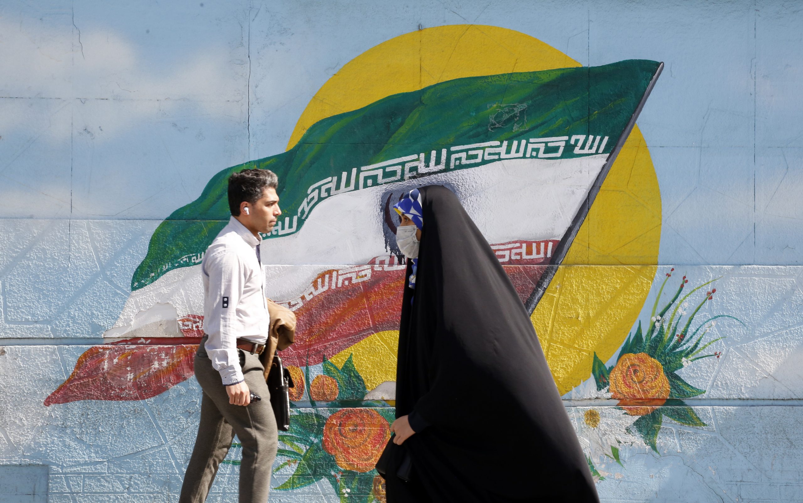 epa10493674 Iranians walk past next to a wall painting of Iran's national flag in downtown Tehran, Iran, 27 February 2023. According to Isna news agency, Iranian foreign minister Amir-Abdoulahian on 26 February 2023 said that Iran is close to reach a nuclear deal with US, after receiving a message from US through Iraq. Iran faces an economic crisis after its currency dropped to its lowest value against the US dollar and other foreign currencies last week, following sanctions imposed by the US and EU, amid tensions over nuclear talks, which have stopped in the wake of recent anti-government protests in the country.  EPA/ABEDIN TAHERKENAREH