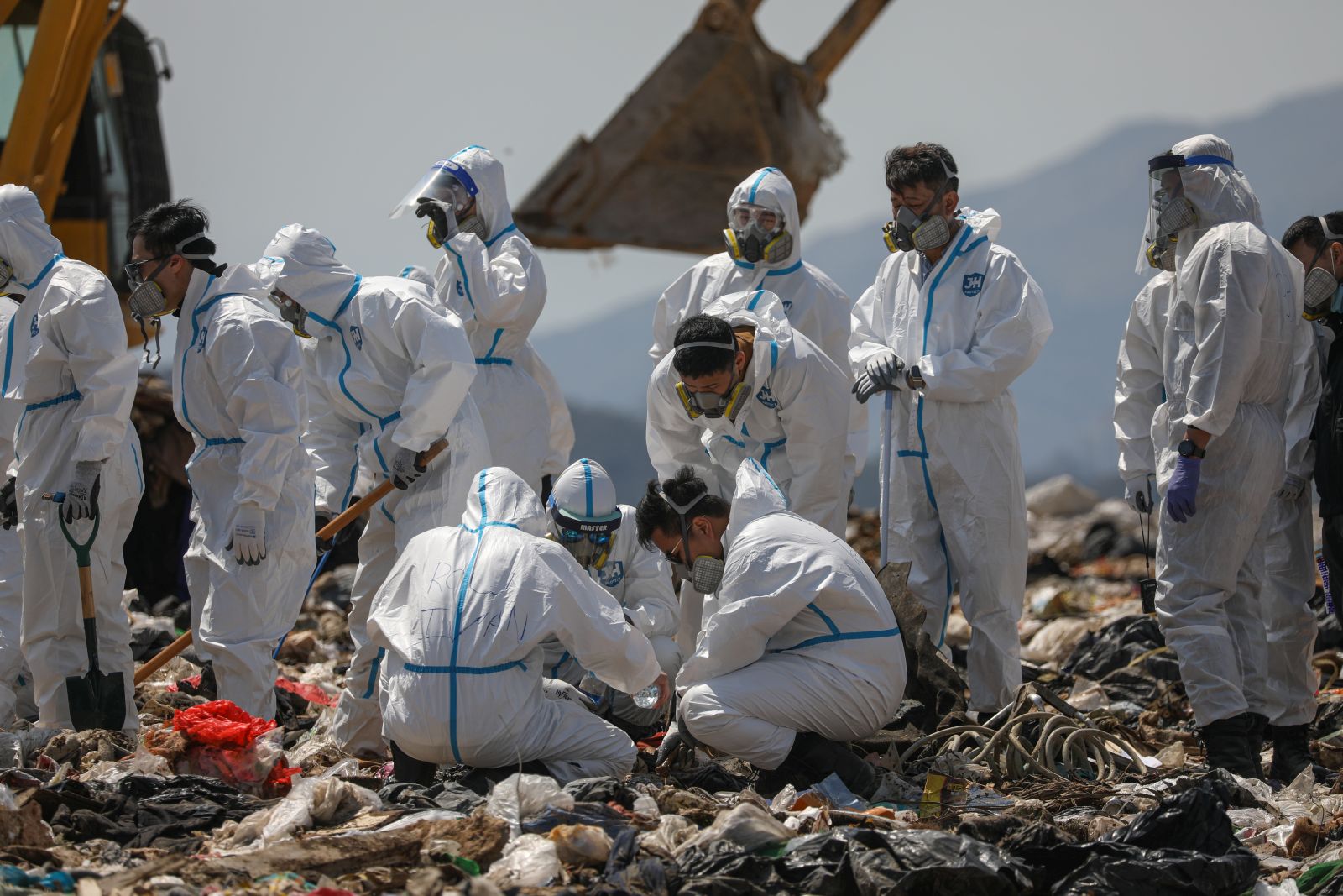 epa10494750 Police officers comb through garbage, searching for the remains of murdered model and influencer Abby Choi in a landfill site in Hong Kong, China, 28 February 2023. Choi’s gruesome murder came to light last week after police found two severed legs, believed to be hers, inside a flat, followed by a skull and several ribs discovered in a large soup pot seized from the property.  EPA/JEROME FAVRE