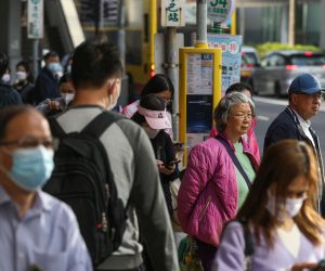 epa10496448 Commuters, with some of them still wearing face masks, wait at a bus stop in Hong Kong, China, 01 March 2023. With the end of the mask mandate on 01 March 2023, residents and visitors to Hong Kong will not have to wear face masks any more for all indoor and outdoor places after almost three years.  EPA/JEROME FAVRE