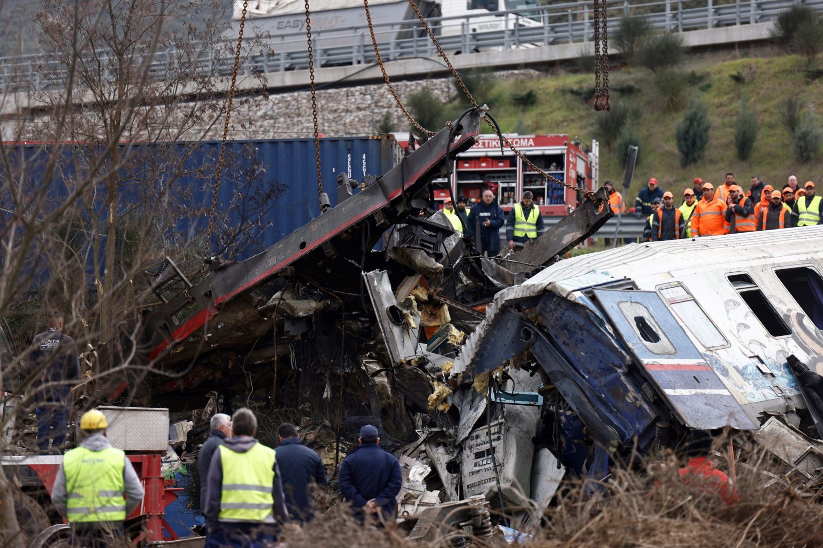 epa10496519 Crane vehicles try to remove pieces of damaged train wagon after a collision near Larissa city, Greece, 01 March 2023. The number of confirmed dead from the deadly train collision at Tempi rises to 36 on Wednesday 01 March morning as the search-and-rescue operation continues, according to the latest update from the fire brigade spokesperson Vasilis Vathrakogiannis. The number of injured in hospital increased to 66, of which six were admitted to ICUs. The search of the wreckage is ongoing, with efforts focused on the first three carriages of the passenger train which overturned, with the assistance of specialised truck-mounted cranes.  EPA/ACHILLEAS CHIRAS