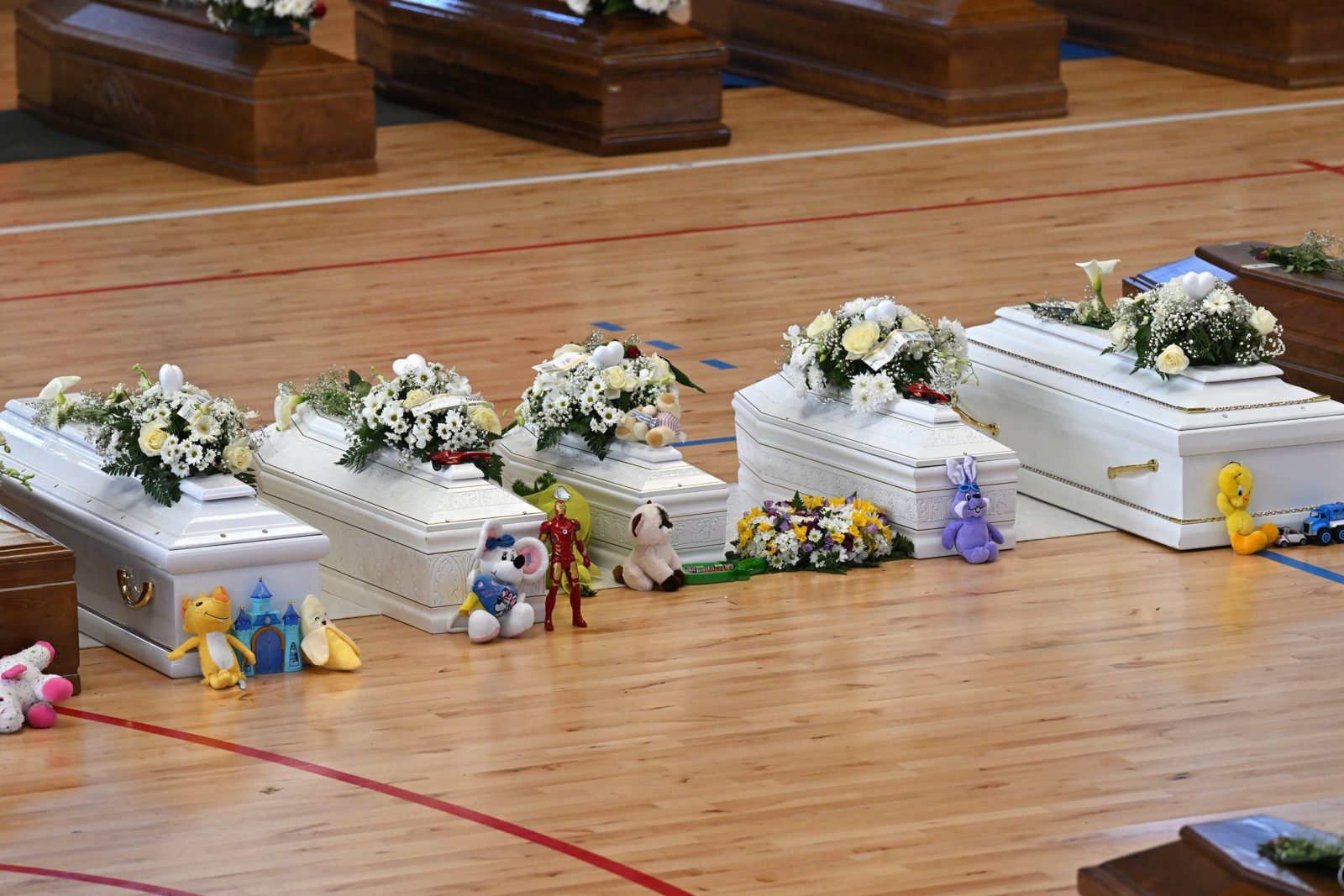 epa10496546 Toys placed near white coffins of the victims who died in a migrant shipwreck, at the Crotone Palasport, the funeral home for the victims, in Steccato di Cutro, Crotone Province, southern Italy, 01 March 2023. The death toll from a shipwreck off Calabria's coast in southern Italy rose to 67 on 01 March 2023, while three men were in detention accused of human trafficking, Italian officials said. A boat carrying migrants sank in rough seas near the Calabrian coast on 26 February.  EPA/CARMELO IMBESI
