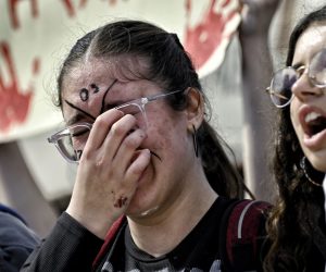 epa10509258 A girl cries during a protest of a nationwide 24-hour strike following a deadly train crash that claimed the lives of at least 57 people, in Athens, Greece, 08 March 2023. The Greek Civil Servants' Confederation (ADEDY) announced a 24-hour nationwide strike in the public sector on 08 March, a week after the deadly head-on train collision that left 57 dead. ADEDY said that the strike is being held 'to demand - together with all the workers and the people - an end to the policy of privatization, and that the real responsibilities for the murderous crime of the Tempi train crash be attributed' to those responsible.  EPA/VASILIS PSOMAS