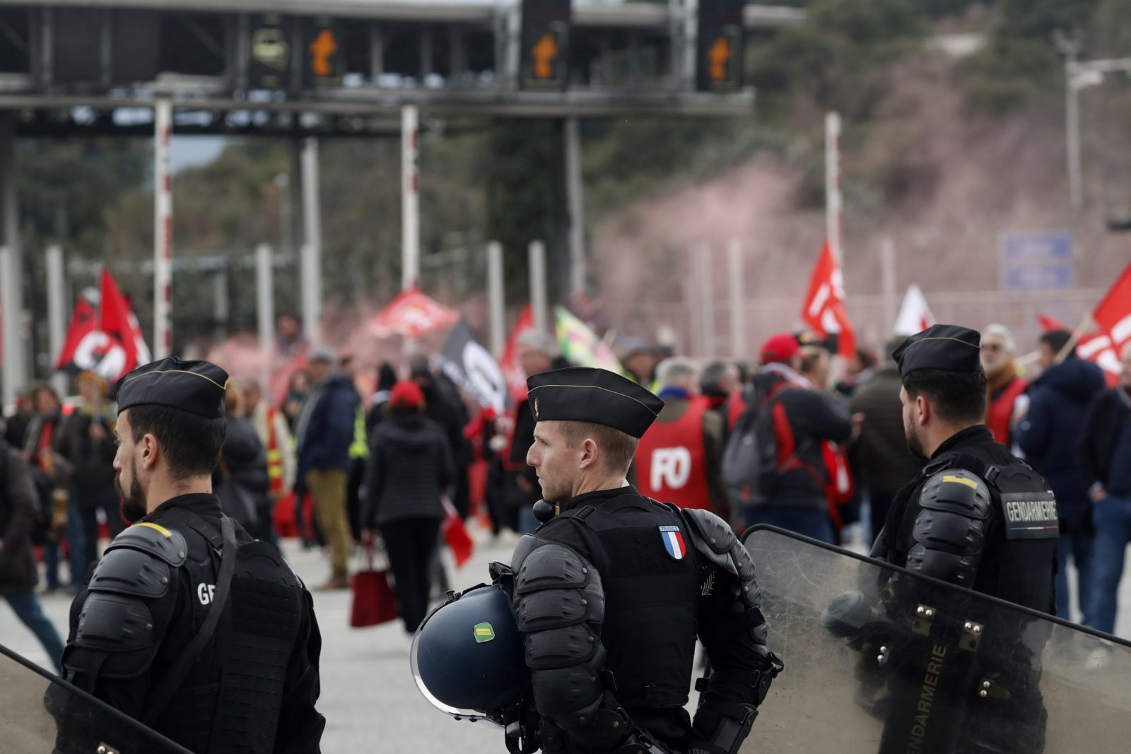 epa10511166 Riot police stand as people block the A9 motorway towards Spain during a new day of protests against the French government's planned reform of the pension system, in Le Boulou, southern France, 09 March 2023. Workers' Force (FO) and General Confederation of Labour (CGT) union members blocked traffic. Protests continue across the country due to the French government's plan to delay the minimum retirement age from 62 to 64 by 2030.  EPA/GUILLAUME HORCAJUELO