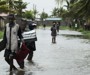 epa10515410 People walk on a flooded street near Quelimane, as the storm Freddy hits in Quelimane, Mozambique, 11 March 2023. The provincial capital of Quelimane will be the largest urban area closest to the cyclone's point of arrival on the mainland, and its radius (of about 300 kilometres) is expected to extend from Marromeu to Pebane, then moving inland towards Cherimane and southern Malawi. This is one of the longest lasting storms ever, after it formed at the beginning of February in the Asian seas, crossing the entire Indian Ocean to the east African coast.  EPA/ANDRÉ CATUEIRA