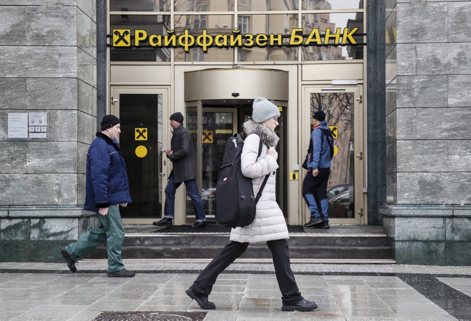 epa10526237 People walk in front of Raiffeisen bank in Moscow, Russia, 16 March 2023. Raiffeisen bank is discussing the exchange of Sberbank's European assets for its own in Russia. Raiffeisen Bank International (RBI) is considering exchange deal in Russia and Austria. Sberbank decided to leave the European market in March 2022, its banking license in the EU has expired, but due to sanctions, it cannot receive the proceeds from the procedure.  EPA/YURI KOCHETKOV