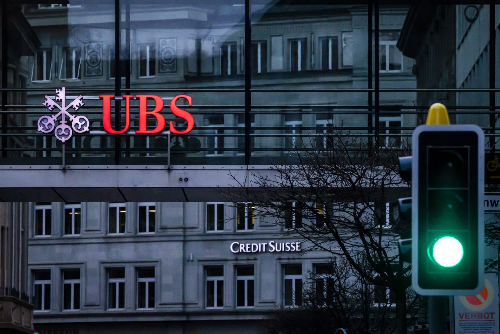 epa10532710 The logos of the Swiss banks Credit Suisse and UBS are displayed on different buildings behind traffic lights in Zurich, Switzerland, 19 March 2023. The bank UBS takes over Credit Suisse for 2 billion US dollars. Shares of Credit Suisse lost more than one-quarter of their value on 15 March 2023, hitting a record low after its biggest shareholder, the Saudi National Bank, told outlets that it would not inject more money into the ailing Swiss bank.  EPA/MICHAEL BUHOLZER