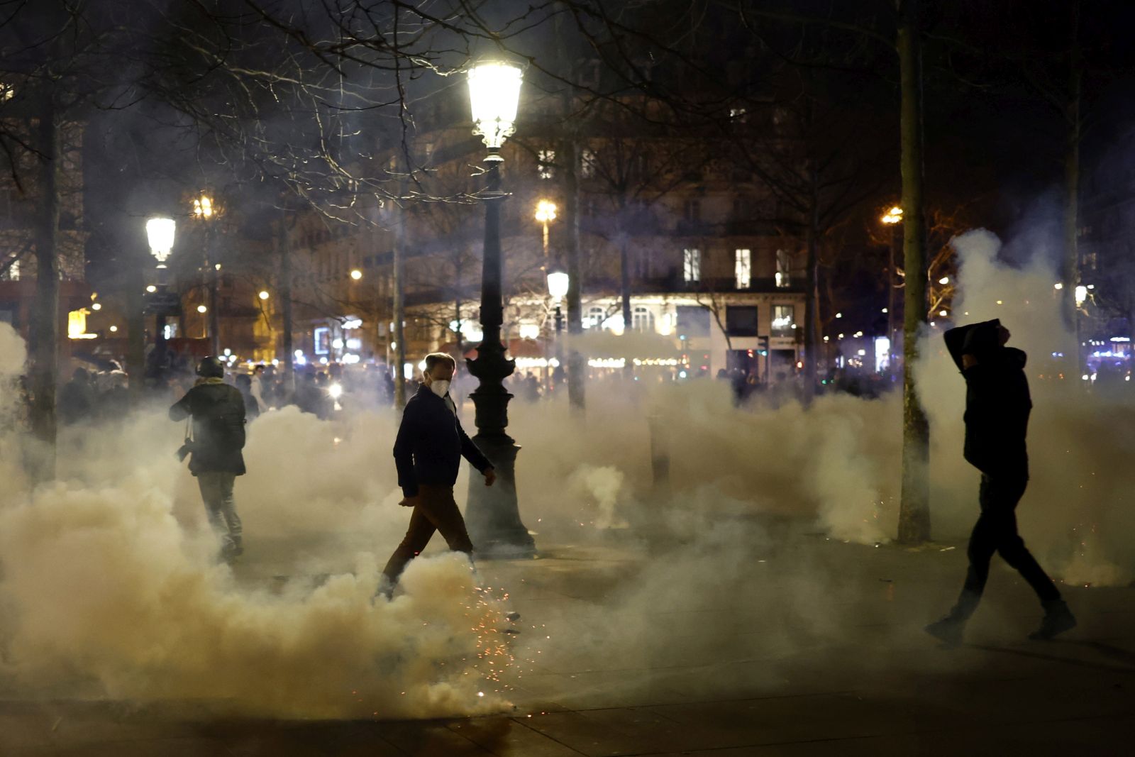 epa10535676 Tear gas floats in the air as protesters clash with French riot police at Republique square during a demonstration against the government pension reform in Paris, France, 21 March 2023. Protests continued in France after the French prime minister announced on 16 March 2023 the use of Article 49 paragraph 3 (49.3) of the French Constitution to have the text on the controversial pension reform law be definitively adopted without a vote in the National Assembly (lower house of parliament). The bill would raise the retirement age in France from 62 to 64 by 2030.  EPA/YOAN VALAT