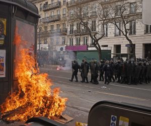 epa10538824 A kiosk is set on fire as French police officers face protesters  during clashes as thousands of people participate in a protest against the government's reform of the pension system in Paris, France, 23 March 2023. Protests continue in France after the prime minister announced on 16 March 2023 the use of Article 49 paragraph 3 (49.3) of the French Constitution to have the text on the controversial pension reform law - raising retirement age from 62 to 64 - be definitively adopted without a vote.  EPA/YOAN VALAT