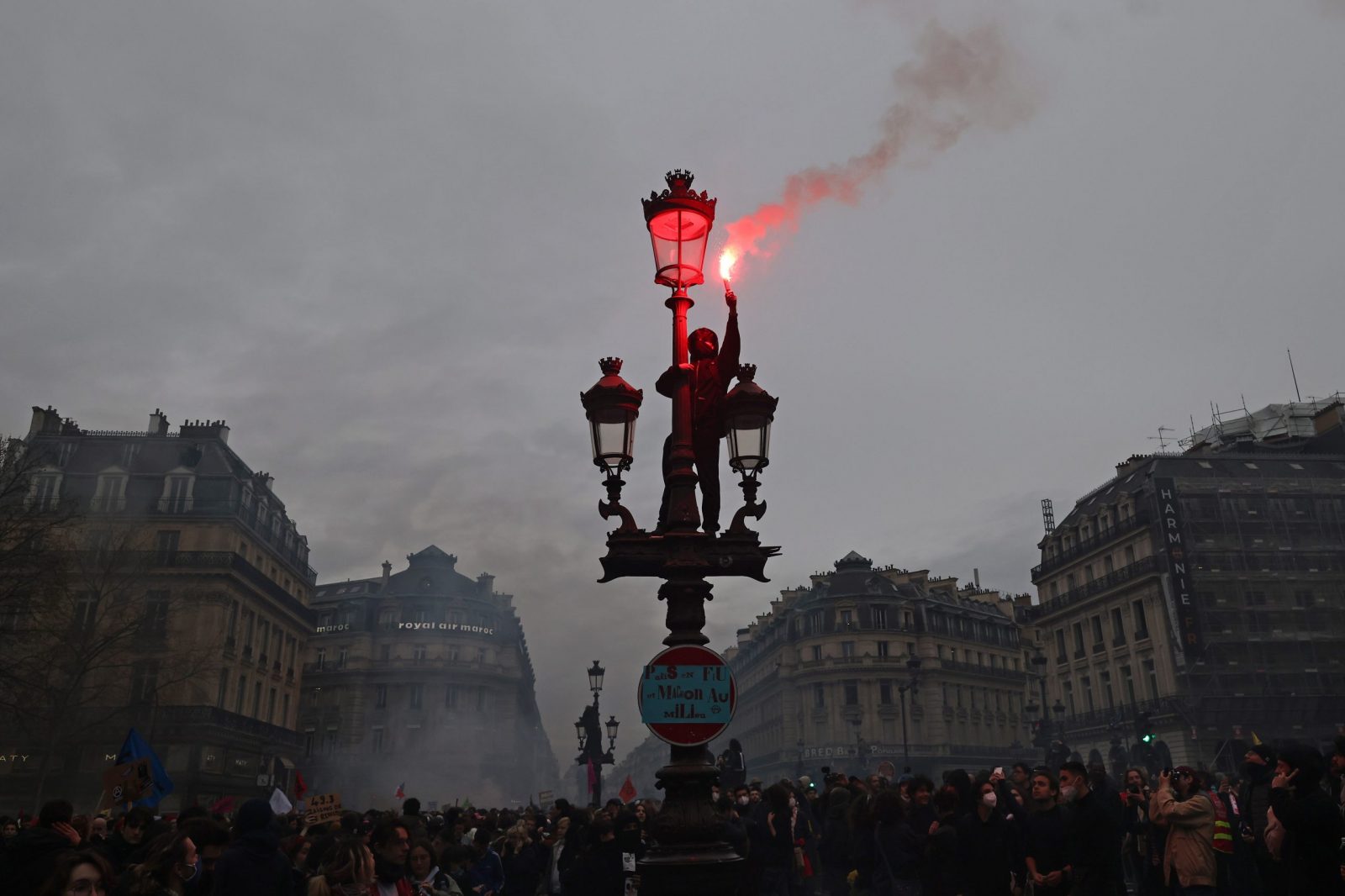 epa10539134 A protester lights a flair as thousands of people participate in a protest against the government's reform of the pension system in Paris, France, 23 March 2023. Protests continue in France after the prime minister announced on 16 March 2023 the use of Article 49 paragraph 3 (49.3) of the French Constitution to have the text on the controversial pension reform law - raising retirement age from 62 to 64 - be definitively adopted without a vote.  EPA/MOHAMMED BADRA