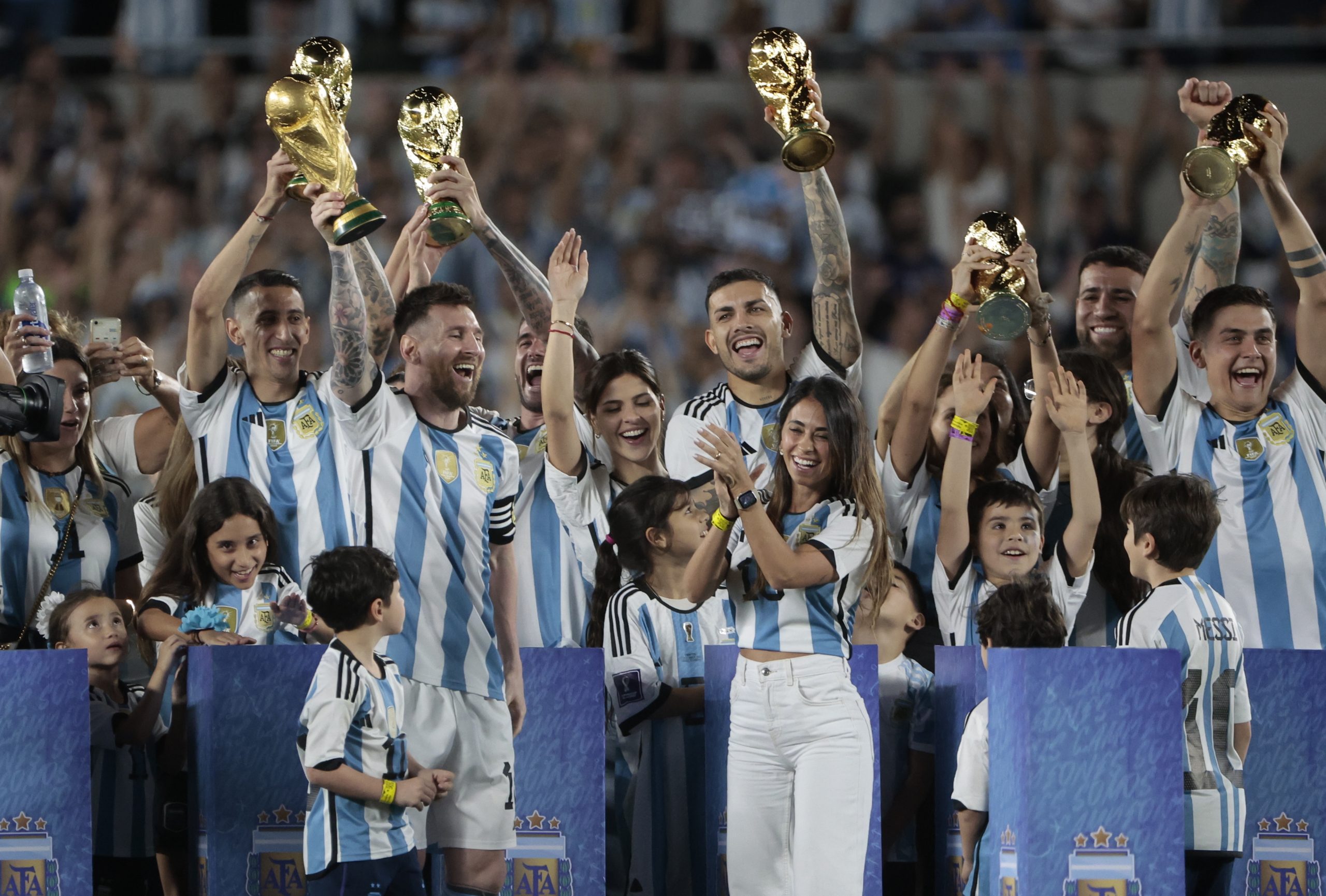 epa10539740 Lionel Messi (L) of Argentina lifts the trophy of FIFA World Cup accompanied by his wife Antonela Roccuzzo (R) and teammates after an international friendly soccer match between the national teams of Argentina and Panama at Monumental stadium in Buenos Aires, Argentina, 23 March 2023.  EPA/JUAN IGNACIO RONCORONI
