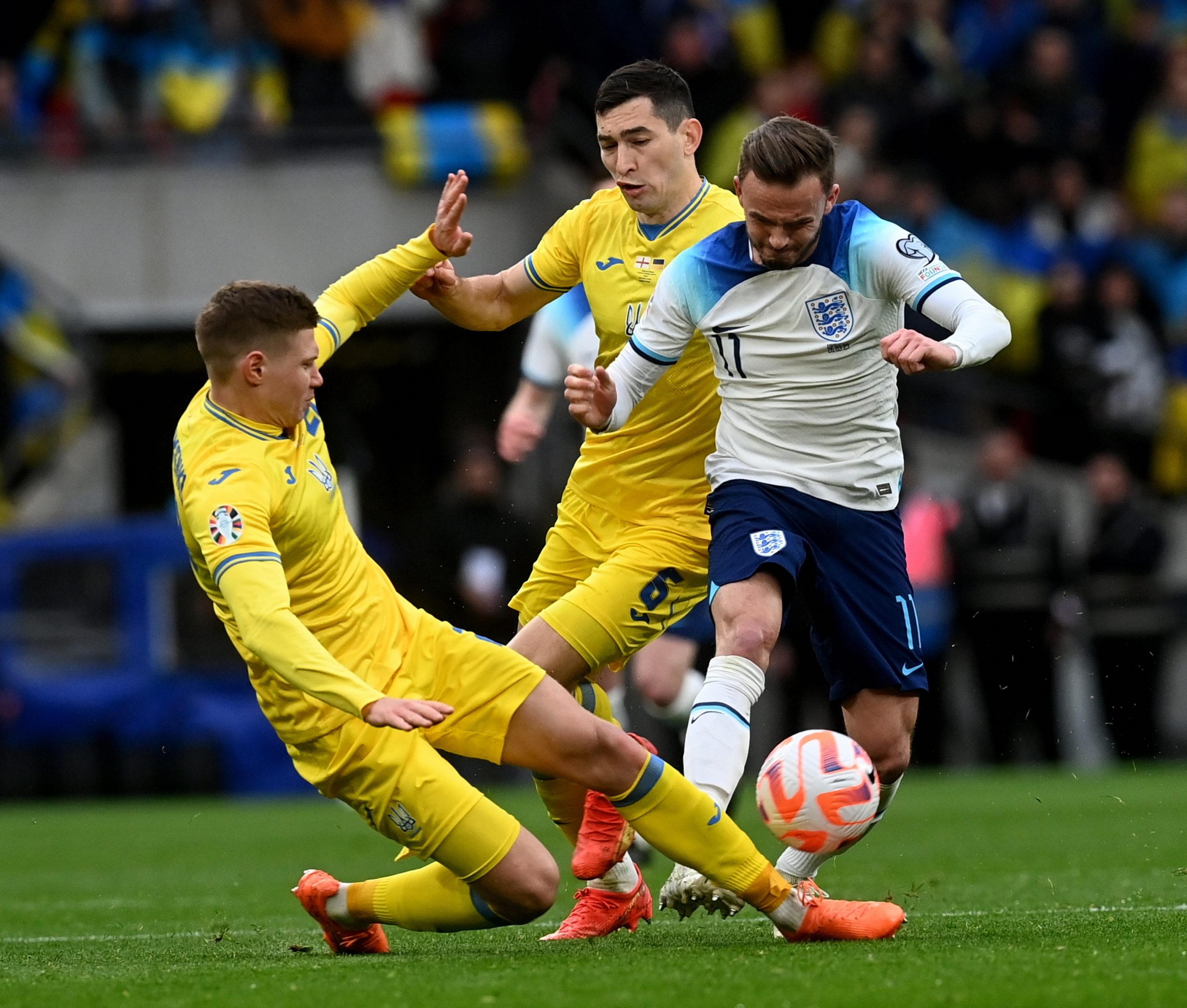 epa10544476 James Maddison (R) of England in action against Taras Stepanenko (C) of Ukraine during the UEFA EURO 2024 qualification match between England and Ukraine in London, Britain, 26 March 2023.  EPA/NEIL HALL