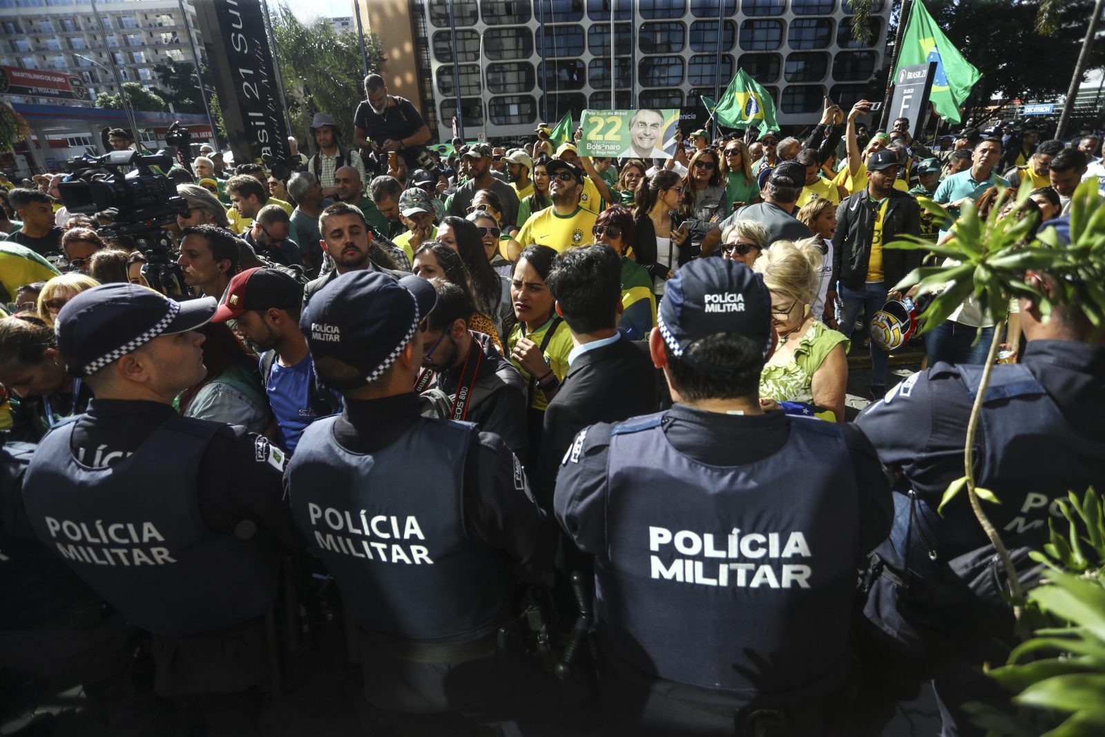 epa10550492 Members of the Military Police watch supporters of former Brazilian president Bolsonaro gather outside the Liberal Party's headquarters in Brasilia, Brazil, 30 March 2023. Bolsonaro returned to Brazil after an 89 days in Florida, USA, to where he traveled two days before his term ended.  EPA/Luis Nova