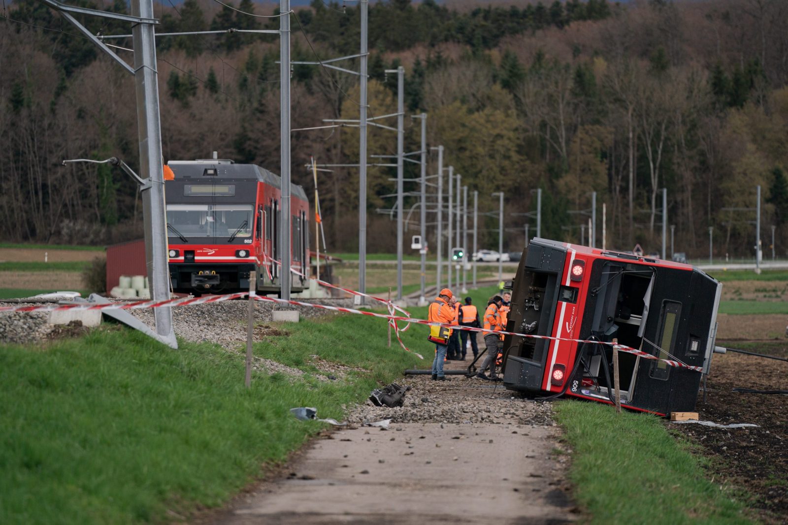 epa10552744 Emergency workers inspect the site of a derailed train of the company Aare Seeland mobil, in Luescherz, Switzerland, 31 March 2023.  EPA/Manuel Lopez