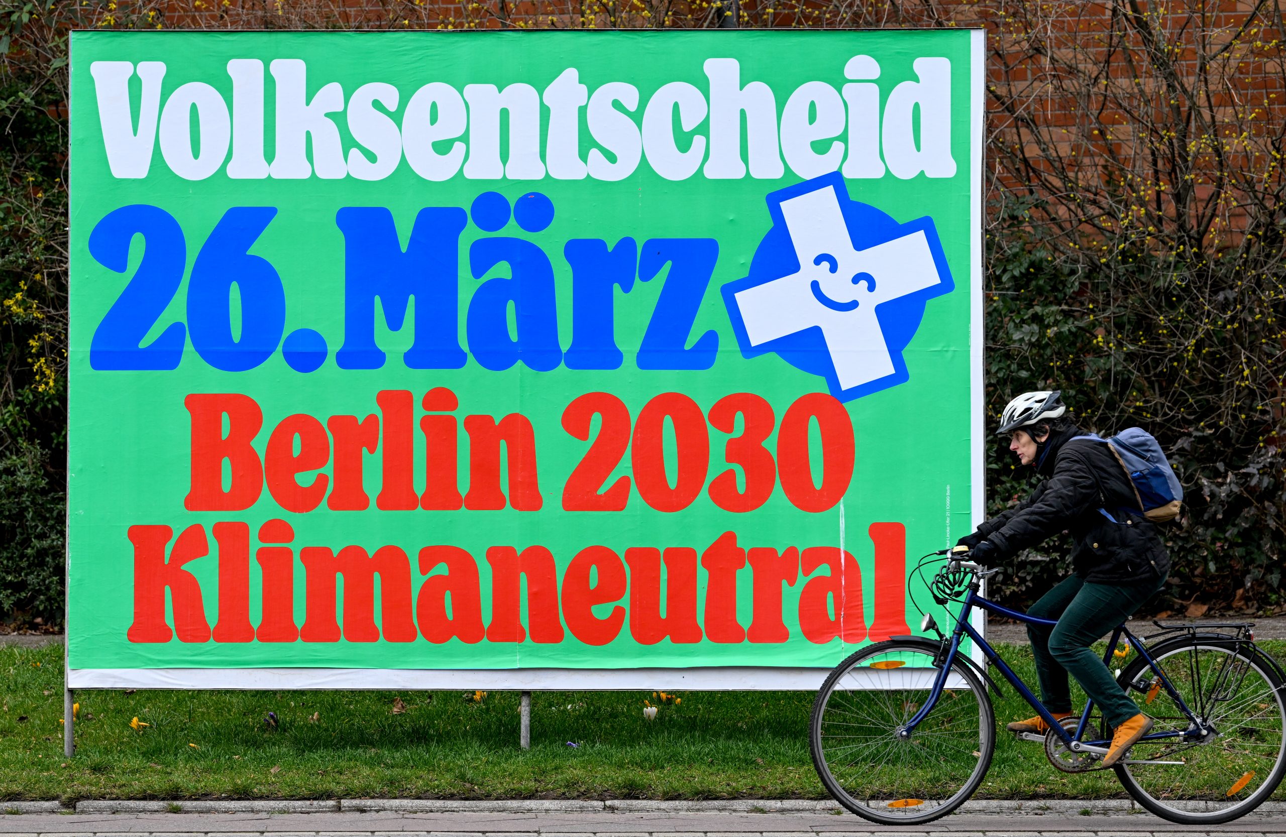 epa10534047 A cyclist passes a billboard promoting Climate Neutrality referendum in Berlin, Germany, 20 March 2023. Berlin Climate-Neutral 2030 referendum is asking the citizens to make Berlin reach its climate targets in 2030. Referendum about climate change take place on 26 March 2023.  EPA/FILIP SINGER
