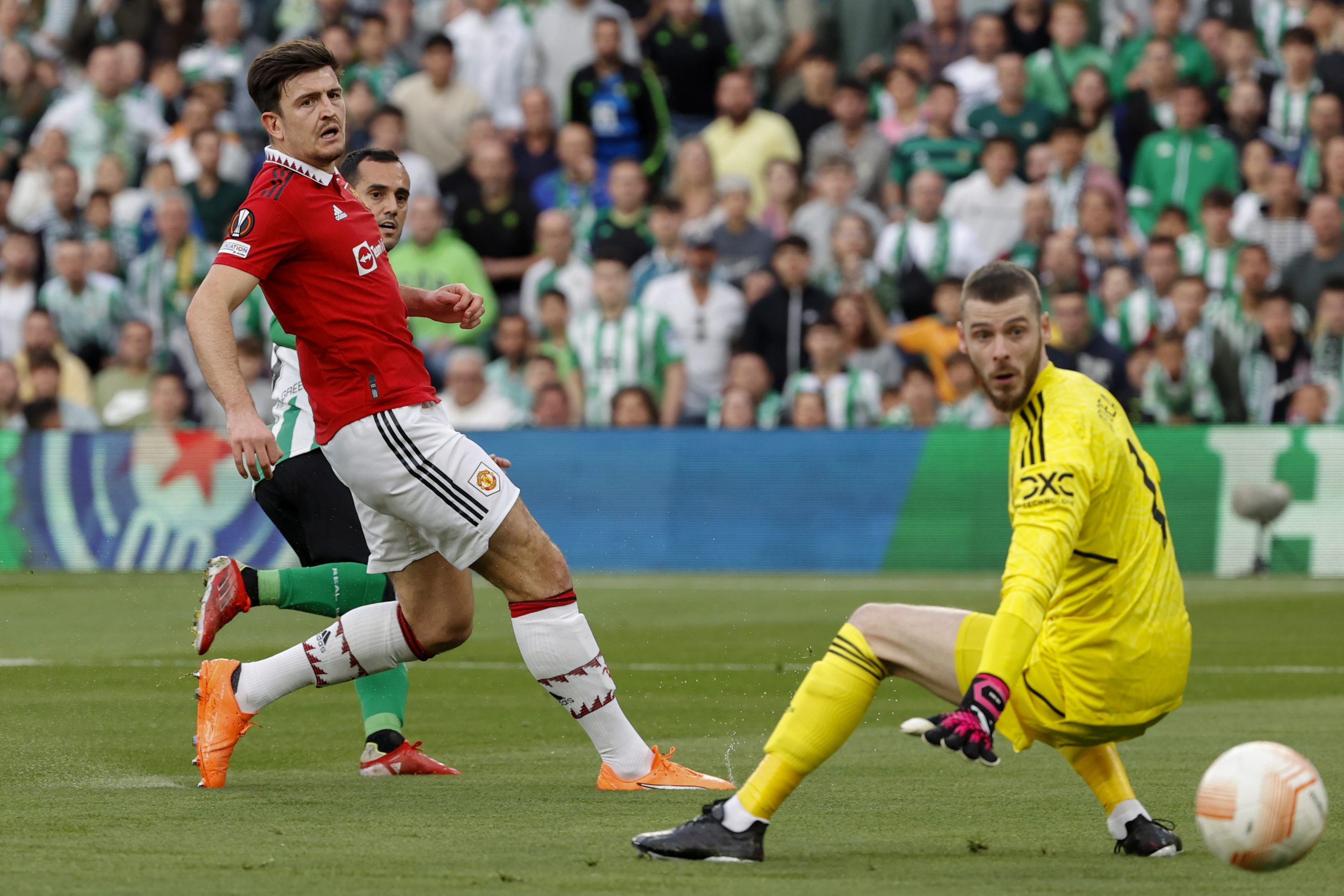 epa10526903 Betis' Joanmi (back) in action against Manchester United's Harry Maguire (C) and goalkeeper David de Gea (R) during the UEFA Europa League round of 16 second leg soccer match between Real Betis and Manchester United, in Seville, southern Spain, 16 March 2023.  EPA/JULIO MUNOZ