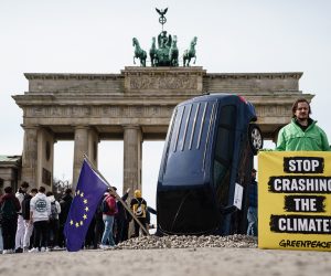 epa10536840 A Greenpeace installation shows an SUV that crashed into the ground before the Brandenburg Gate, as part of a protest against the German blockade of a European phase-out of combustion engines, in Berlin, Germany, 22 March 2023.  EPA/CLEMENS BILAN