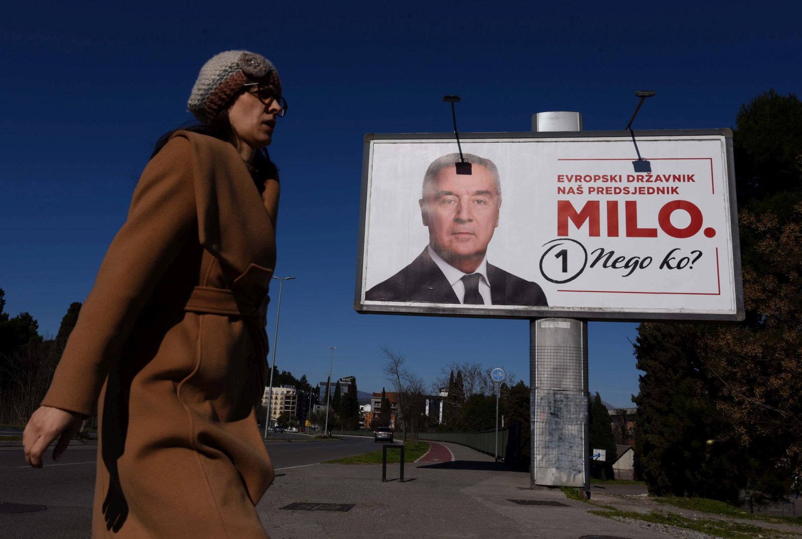 epa10528207 A woman walks past a campaign billboard of the Presidential candidate and incumbent President Milo Djukanovic ahead of the upcoming Presidential elections in Podgorica, Montenegro, 17 March 2023. Presidential elections are due to be held in Montenegro on 19 March 2023.  EPA/BORIS PEJOVIC
