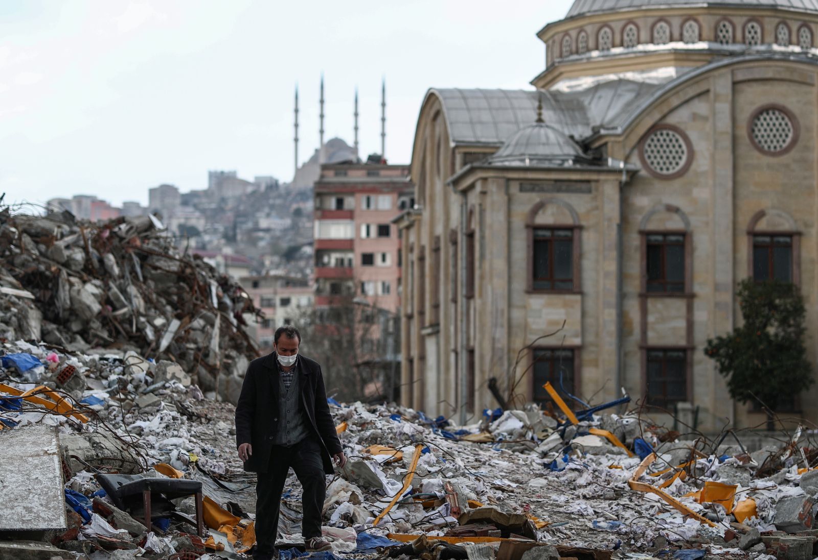 epa10541042 A man walks on debris during the Ramadan in the aftermath of a powerful earthquake in Kahramanmaras, Turkey, 24 March 2023. More than 50,000 people died and thousands more were injured after major earthquakes struck southern Turkey and northern Syria on 06 February and again on 20 February 2023.  EPA/ERDEM SAHIN