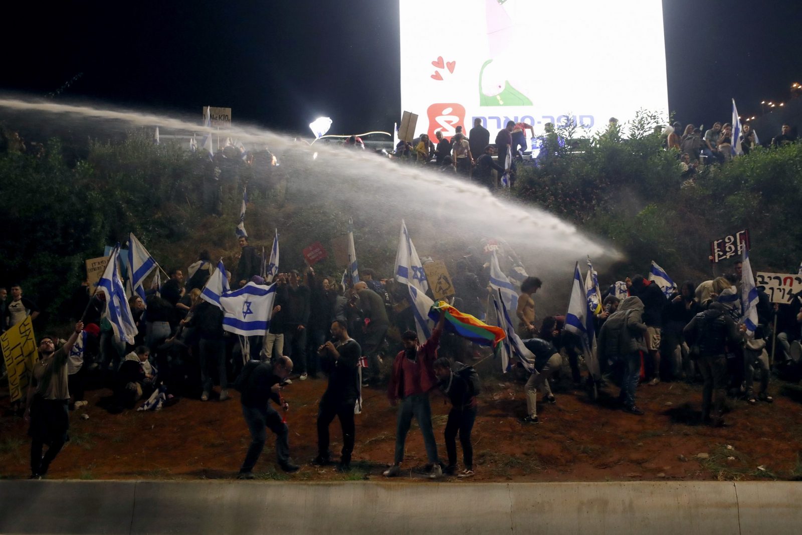 epa10554319 Police use water canons to disperse demonstrators in Ayalon highway during a protest against the government's justice system reform plans in Tel Aviv, Israel, 01 April 2023. Israeli prime minister announced on 27 March his government's suspension of a judicial overhaul legislation and starting negotiations with opposition leaders after 12 weeks of mass protests across the country.  EPA/ATEF SAFADI