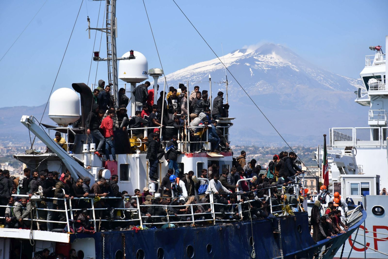 epa10569476 Some of the 600 migrants rescued on a trawler some 100 miles of the coast of Sicily arrive in the port of Catania, Italy, 12 April 2023. The vessel was escorted by the 'Nave Peluso' of the Coast Guard on the same day after over 200 people rescued at sea also landed in Catania and Messina on two other Coast Guard vessels. The Italian government on 11 April called a state of emergency on all the national territory following the exceptional rise in migrant flows across the Mediterranean.  EPA/ORIETTA SCARDINO