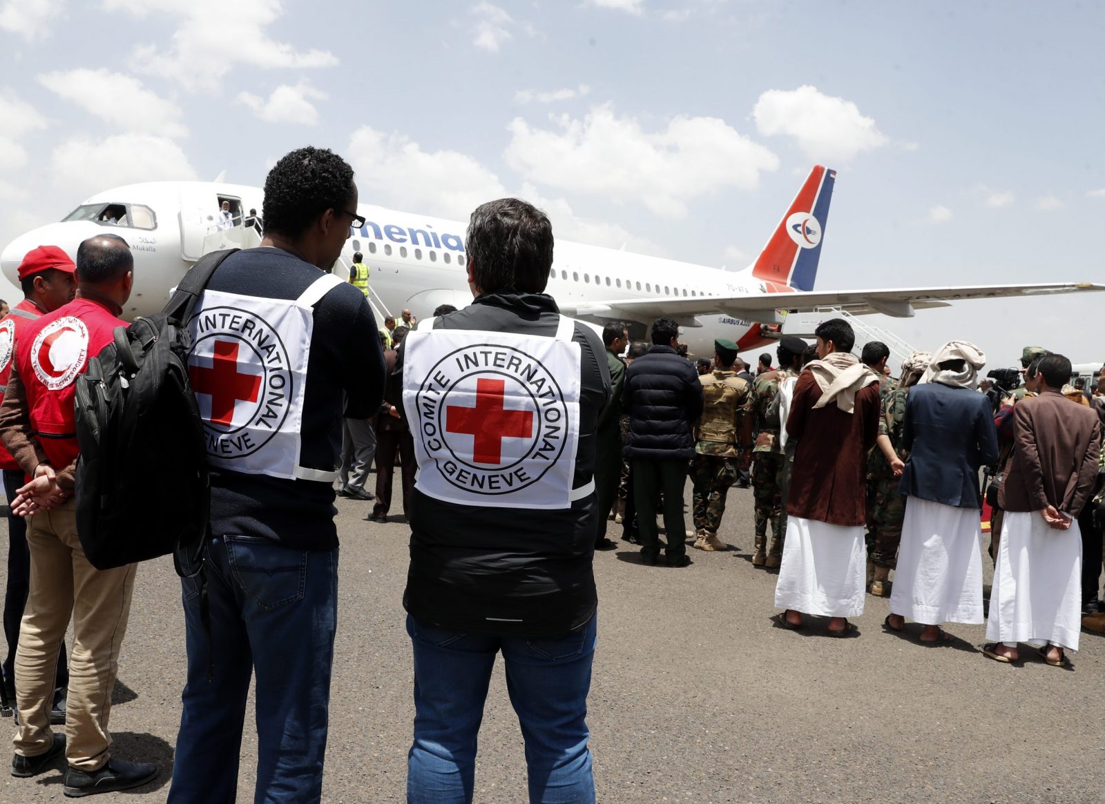 epa10572345 ICRC members stand near a plane carrying freed prisoners loyal to Houthis upon their arrival at Sanaa Airport, on the first day of a prisoner swap, in Sana'a, Yemen, 14 April 2023. According to the International Committee of the Red Cross (ICRC), Yemen's warring parties began on 14 April a three-day exchange of 887 prisoners. The Houthis have agreed to release 181 detainees, including Saudis and Sudanese soldiers who fought alongside Yemeni government forces, in exchange for 706 prisoners held by the Yemeni government, under the UN and ICRC-brokered prisoner swap deal reached last March in Switzerland.  EPA/YAHYA ARHAB