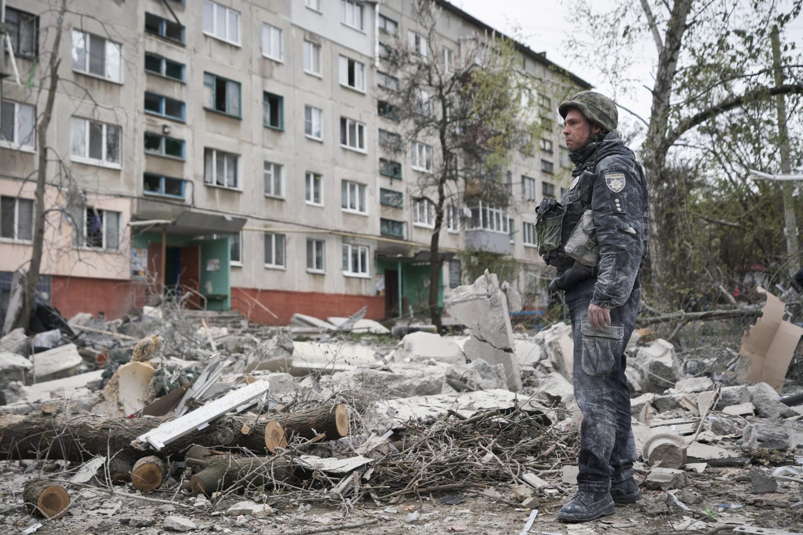 epa10572737 A policeman stands at the scene of a Russian rocket attack on a residential building in the city of Sloviansk in Donetsk, Ukraine, 14 April 2023. At least 5 people died and 15 were injured according to the regional governor.  EPA/YEVGEN HONCHARENKO