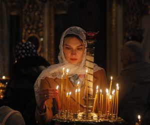epa10575542 A Ukrainian woman lights a candle as faithful attend an Orthodox Easter mass at St. Volodymyr Cathedral in Kyiv (Kiev), Ukraine, 16 April 2023. Eastern Orthodox Christians worldwide celebrate Easter on 16 April 2023, according to the Julian calendar. Christians celebrate Easter Sunday to mark the resurrection of Jesus Christ from the dead and the foundation of the Christian faith.  EPA/SERGEY DOLZHENKO