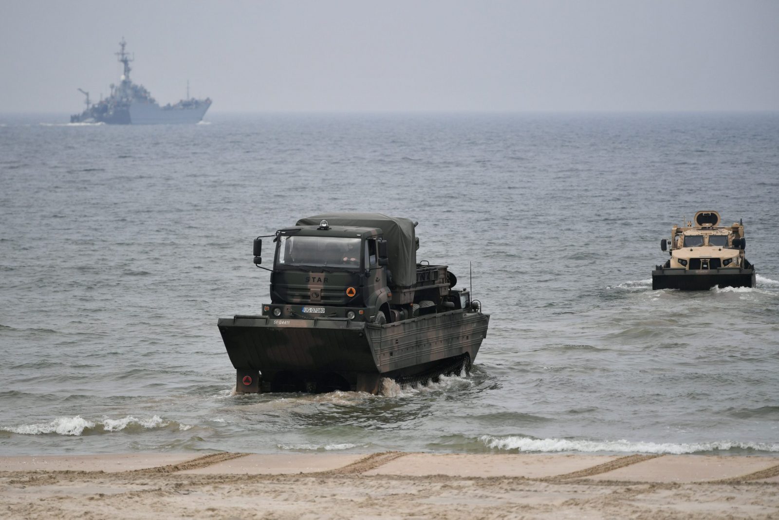 epa10576973 Amphibious vehicles land on a beach section in tactical exercises of the 16th Mechanized Division along with allied troops under the codename 'Zalew-23', in Skowronki near the Vistula Spit canal, northern Poland, 17 April 2023. Following a break over the Easter holidays some 2,500 soldiers from units of the Land Forces, the Navy, Territorial Defense Forces and allied forces that are part of the NATO Battalion Battle Group and the Engineering Forces, continued to take part in the military exercise aimed at responding to threats of military and non-military nature from the sea, using the new waterway through the Vistula Spit, in the border area on the Vistula Lagoon, according to the Polish Armed Forces.  EPA/Adam Warzawa POLAND OUT
