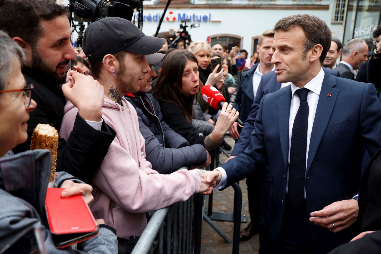 epa10580233 French President Emmanuel Macron (R) shakes hands with people during a visit in Selestat, eastern France, 19 April 2023. Macron, whose reforms including an increase to the pension age have earned him widespread animosity in recent weeks, makes a visit on the theme of reindustrialisation.  EPA/LUDOVIC MARIN / POOL  MAXPPP OUT