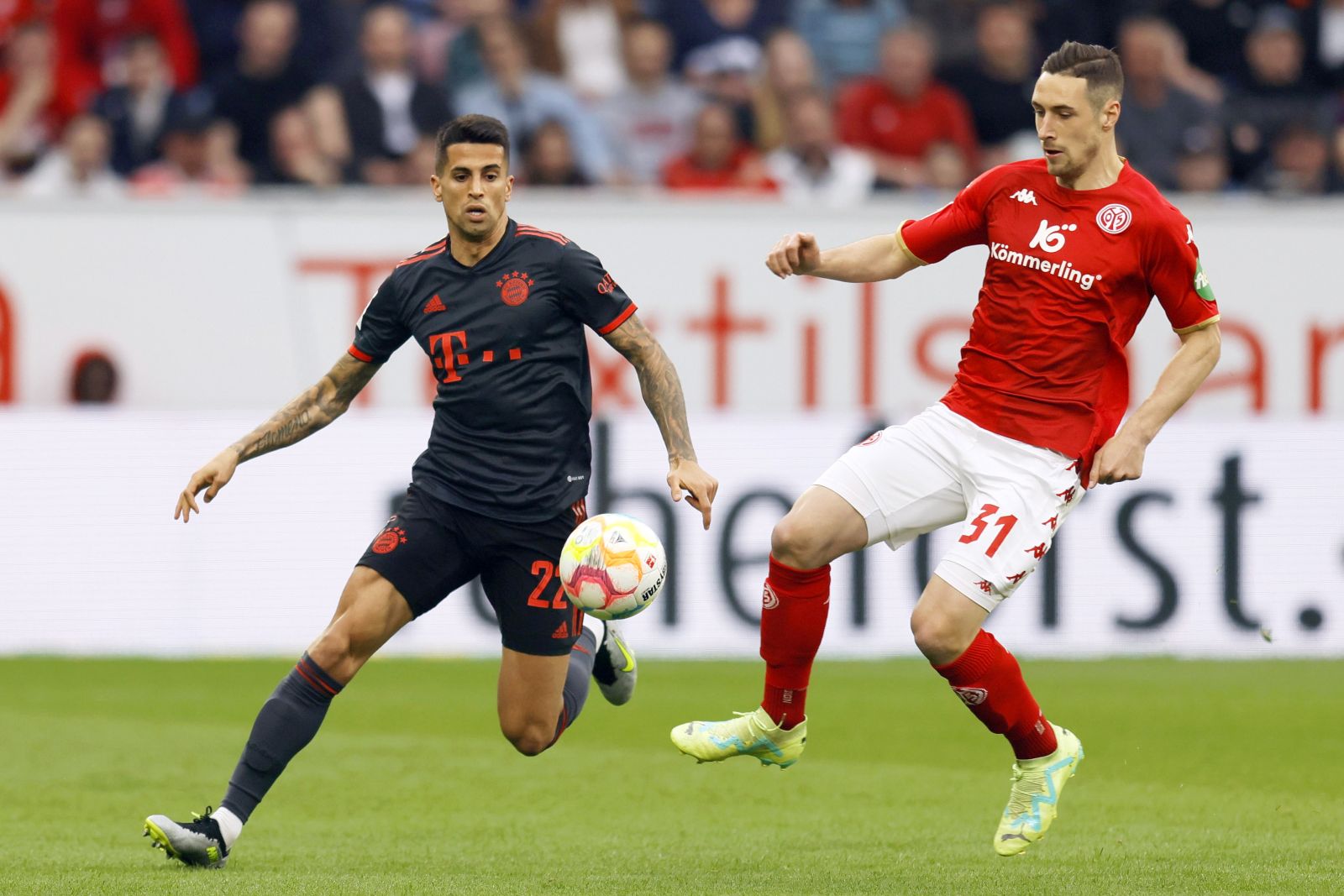 epa10585693 Munich's Joao Cancelo (L) in action against Mainz’s Dominik Kohr (R) during the German Bundesliga soccer match between 1. FSV Mainz 05 and FC Bayern Munich in Mainz, Germany, 22 April 2023.  EPA/RONALD WITTEK CONDITIONS - ATTENTION: The DFL regulations prohibit any use of photographs as image sequences and/or quasi-video.