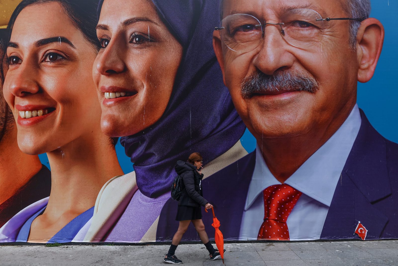 epa10591376 A woman walks in front of the picture of Turkish presidential candidate Kemal Kilicdaroglu's, leader of opposition Republican People’s Party (CHP), in Istanbul, Turkey, 25 April 2023. General elections will be held in Turkey on 14 May 2023 with a two-round voting to elect the President of Turkey and parliamentary elections held simultaneously to elect the members the Grand National Assembly of Turkey.  EPA/SEDAT SUNA