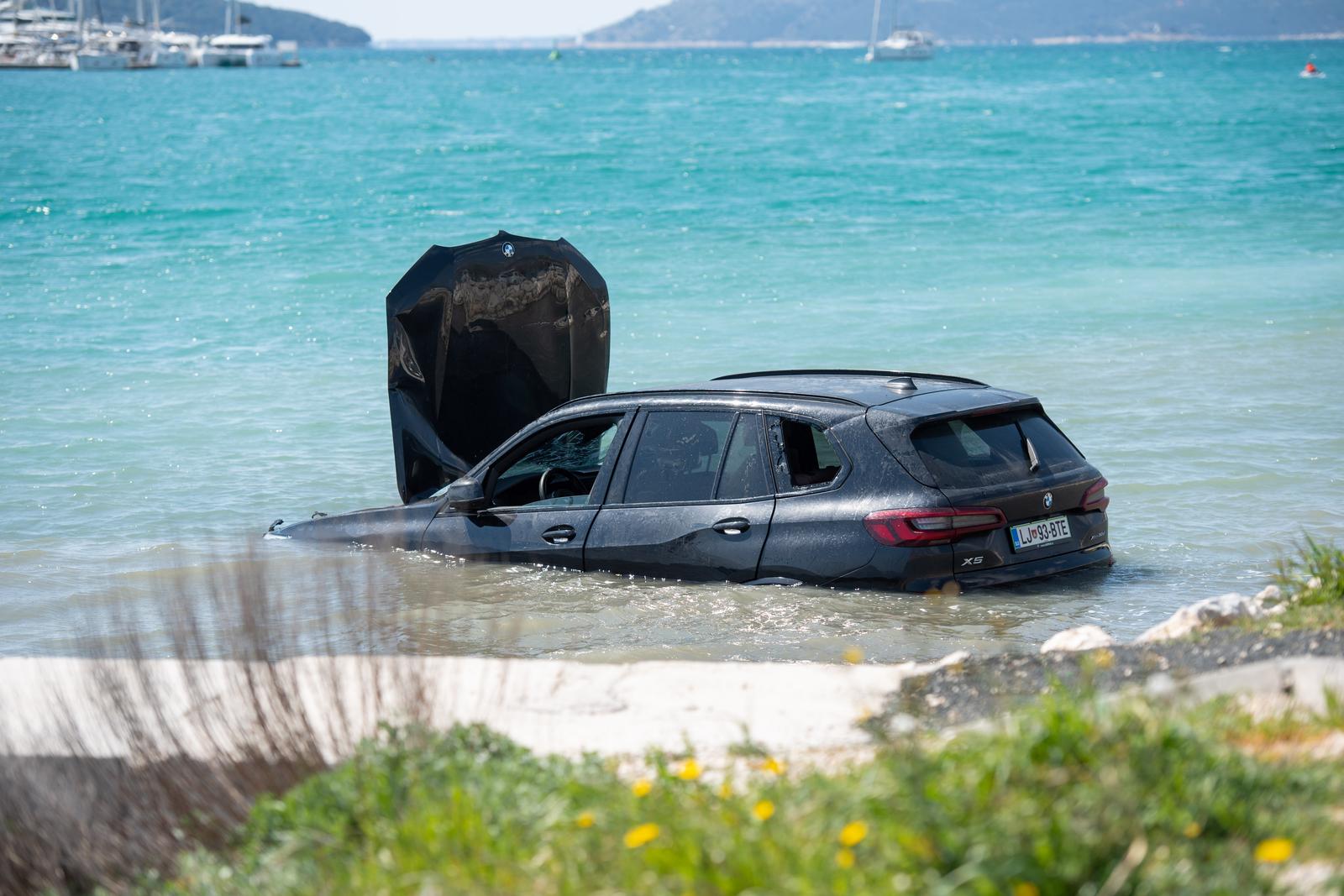 07.04.2023., pristaniste Soline, Trogir – BMW udario u parkirani kamion. Oba vozila zavrsila su u moru. Vatrogasci izvukli vozacicu iz BMW-a koja je potom, vozilom HMP-a, prevezena na pružanje lječničke pomoći.   Photo: Josko Herceg/PIXSELL