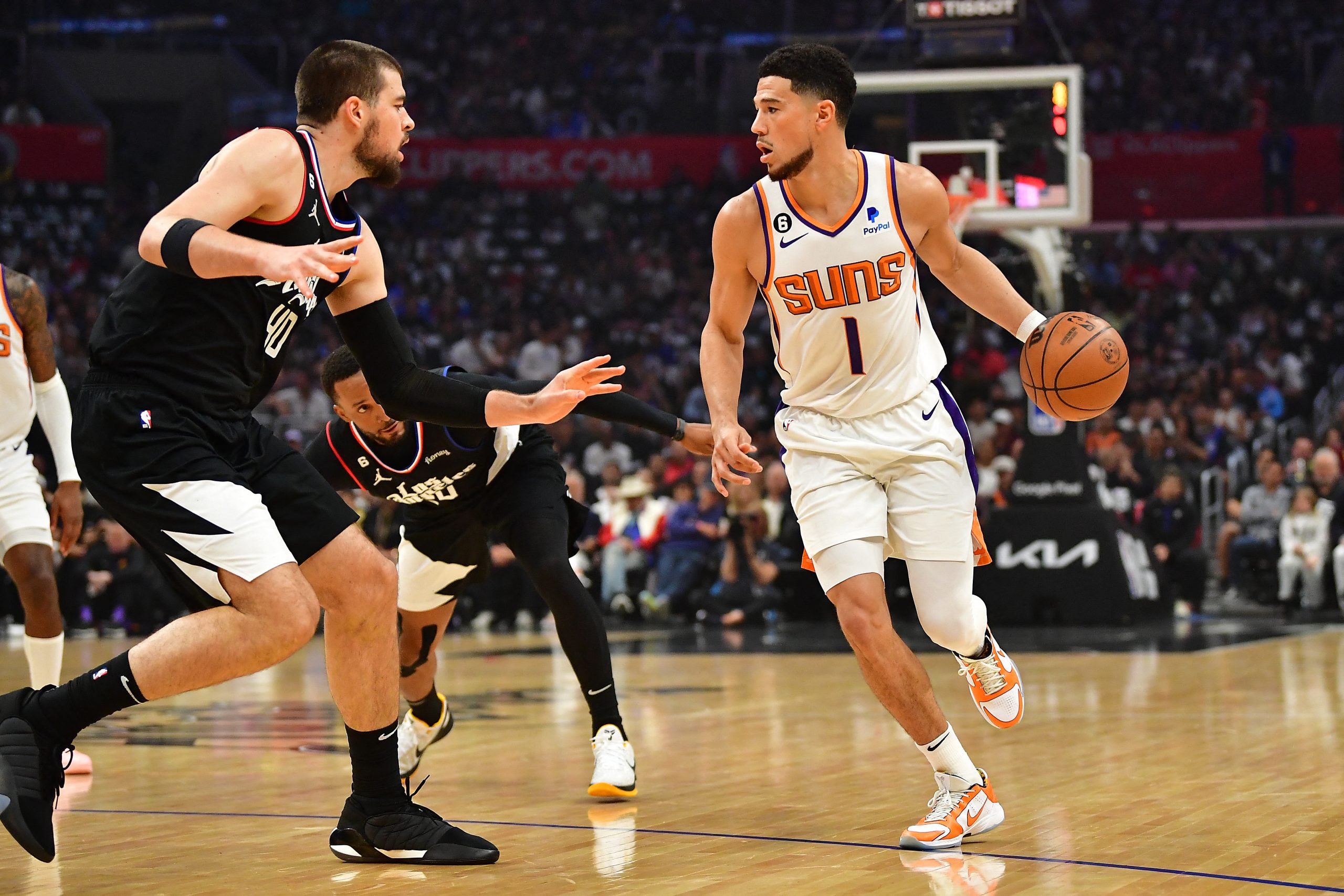 Apr 22, 2023; Los Angeles, California, USA; Phoenix Suns guard Devin Booker (1) moves the ball against Los Angeles Clippers center Ivica Zubac (40) during the first half in game four of the 2023 NBA playoffs at Crypto.com Arena. Mandatory Credit: Gary A. Vasquez-USA TODAY Sports Photo: Gary A. Vasquez/REUTERS
