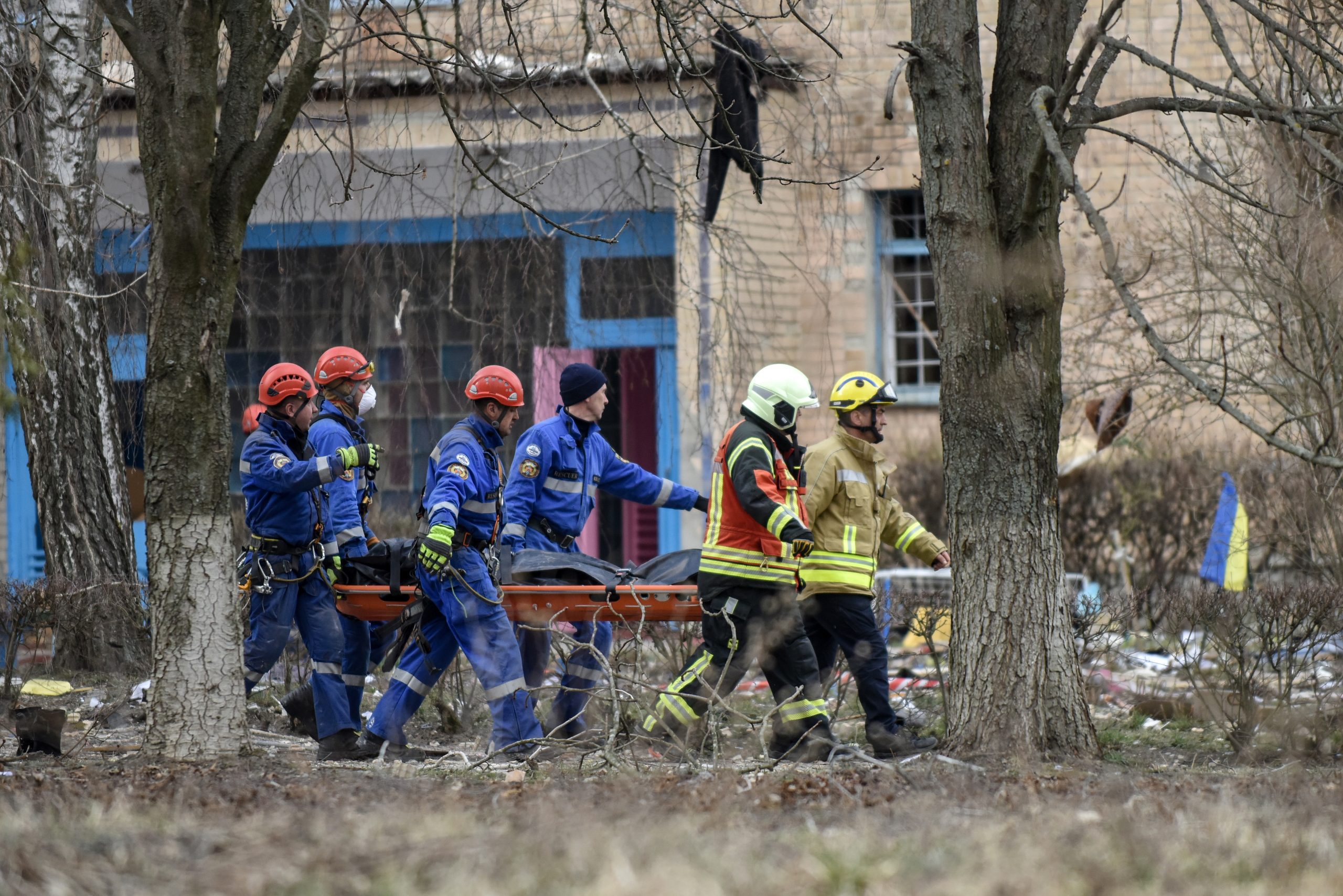 epa10537059 Rescue workers carry the body of a victim at the site of a buliding damaged by drone strikes in the town of Rzhyshchiv, Ukraine, 22 March 2023. According to the State Emergency Service of Ukraine, at least six people died on 22 March following a Russian overnight drone strikes on Rzhyshchiv.  EPA/OLEG PETRASYUK