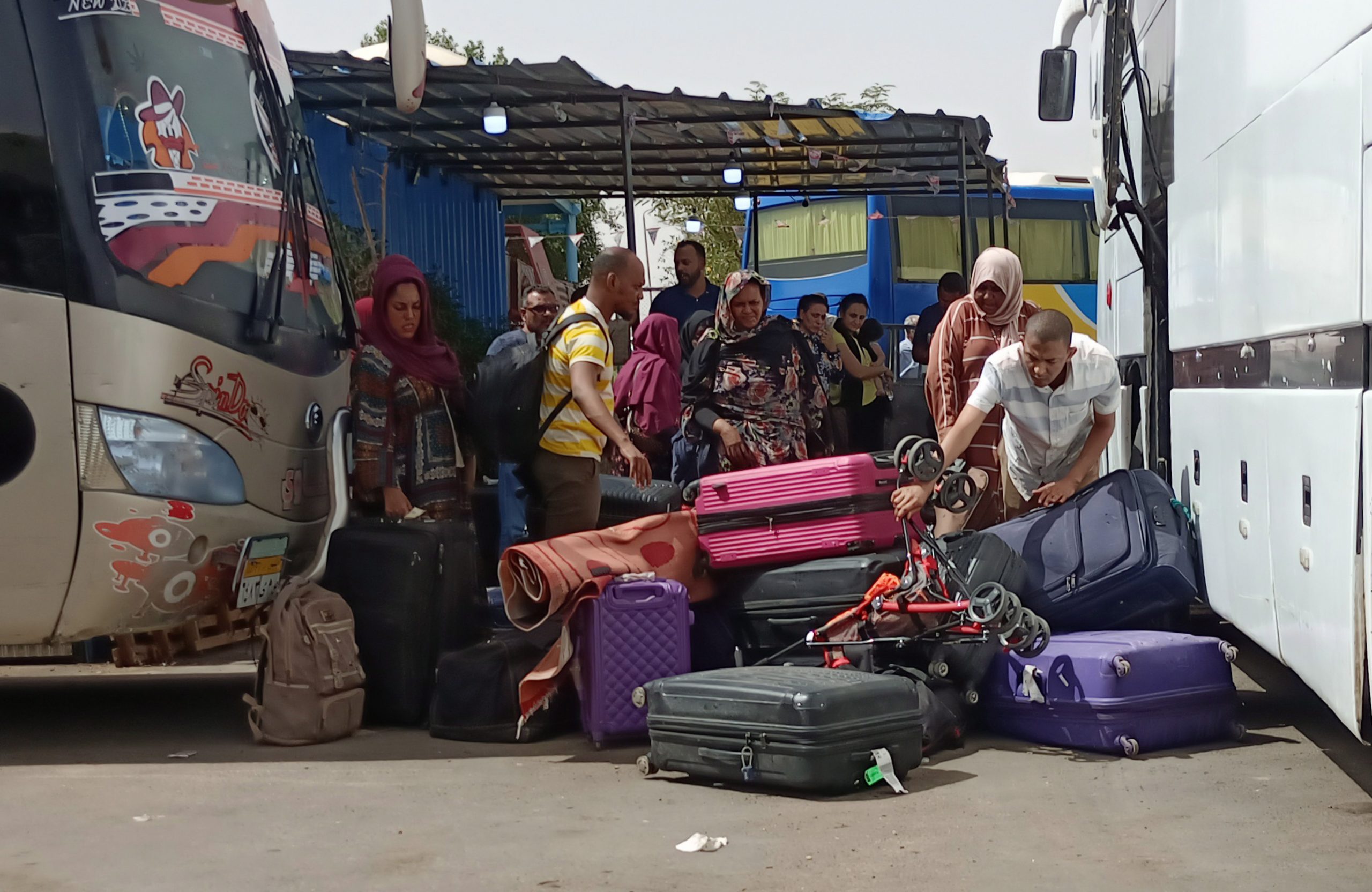 epa10590996 Passengers fleeing from Sudan arrive at Wadi Karkar bus station in Aswan, Egypt 25 April 2023. Heavy armed clashes between the country's military and rival paramilitary groups have occurred in the capital Khartoum and other parts of the country since 15 April 2023.  EPA/STR